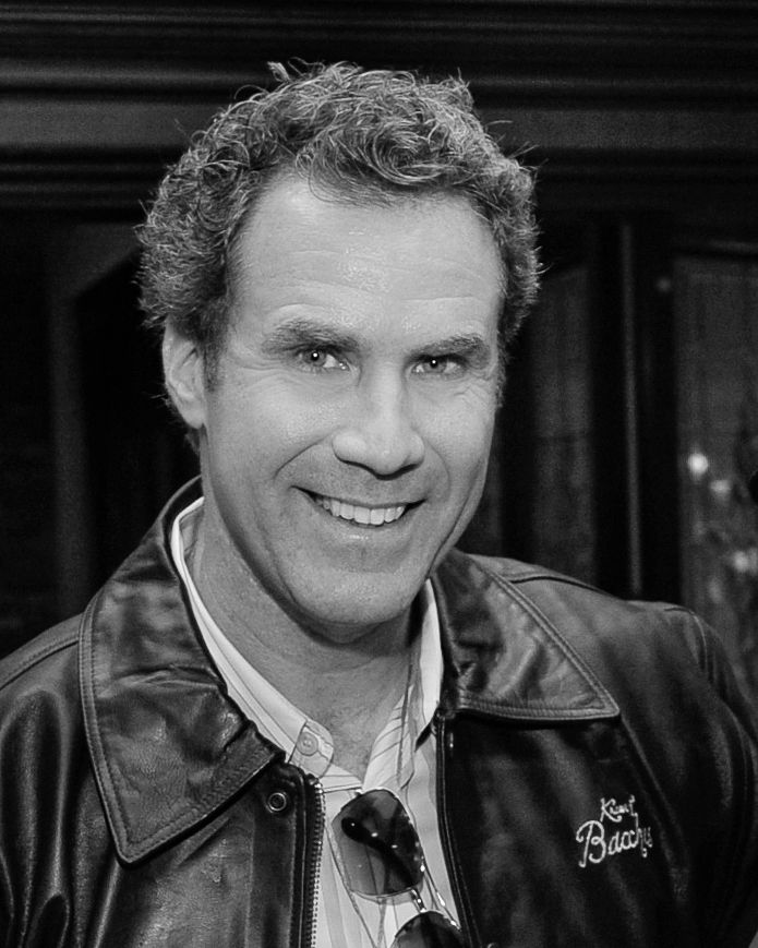 Black and white portrait of entertainer in leather jacket showing warm, engaging smile.