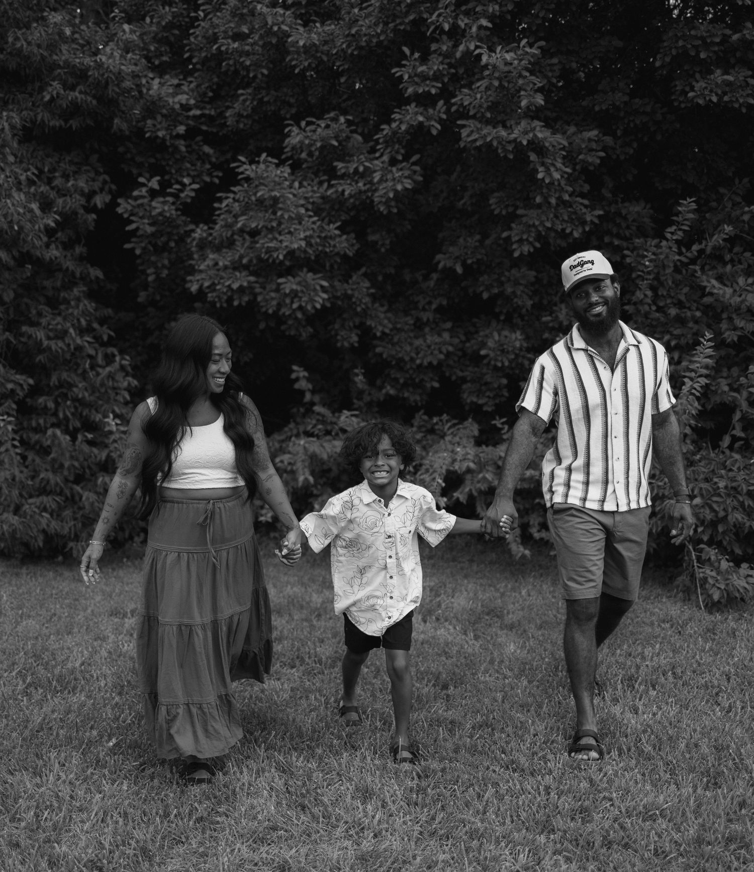 Black and white photo series showing people walking and playing together in a grassy outdoor setting.