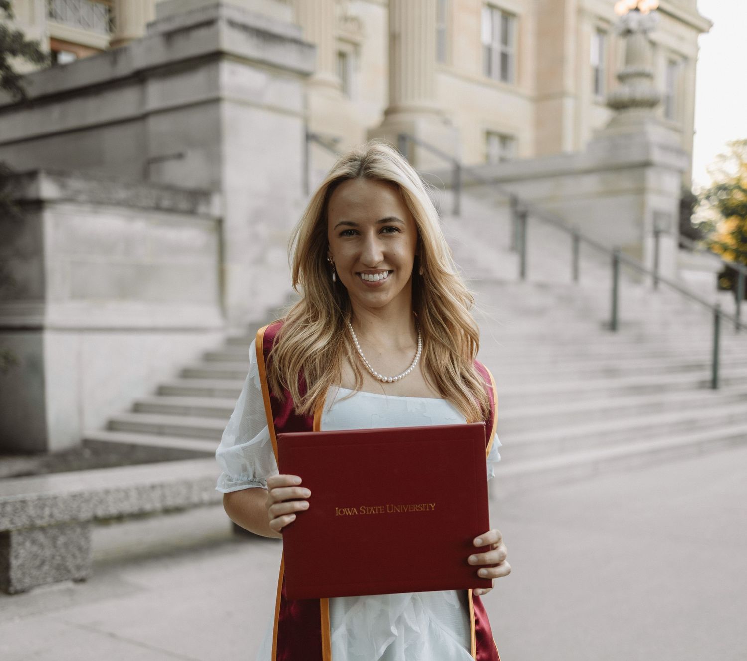 A series of photos showing someone holding a red diploma cover while standing on stone steps outdoors.