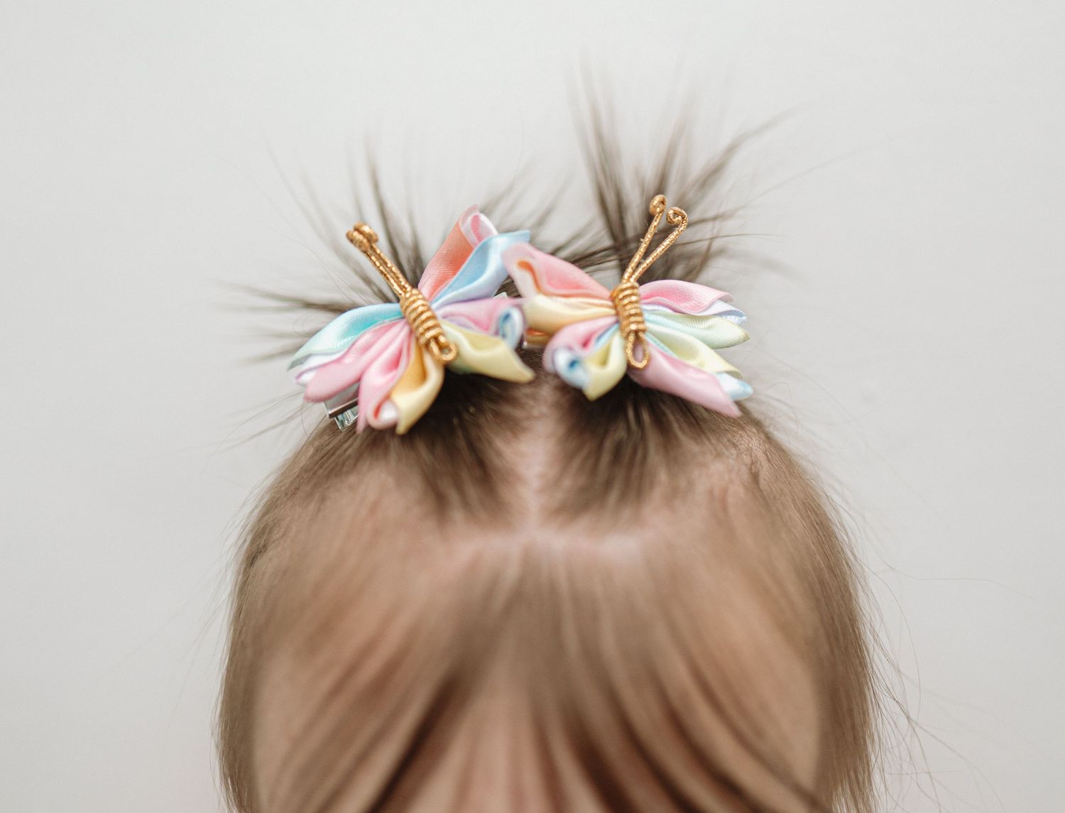 A white butterfly hair clip shown in multiple angles against a neutral background.