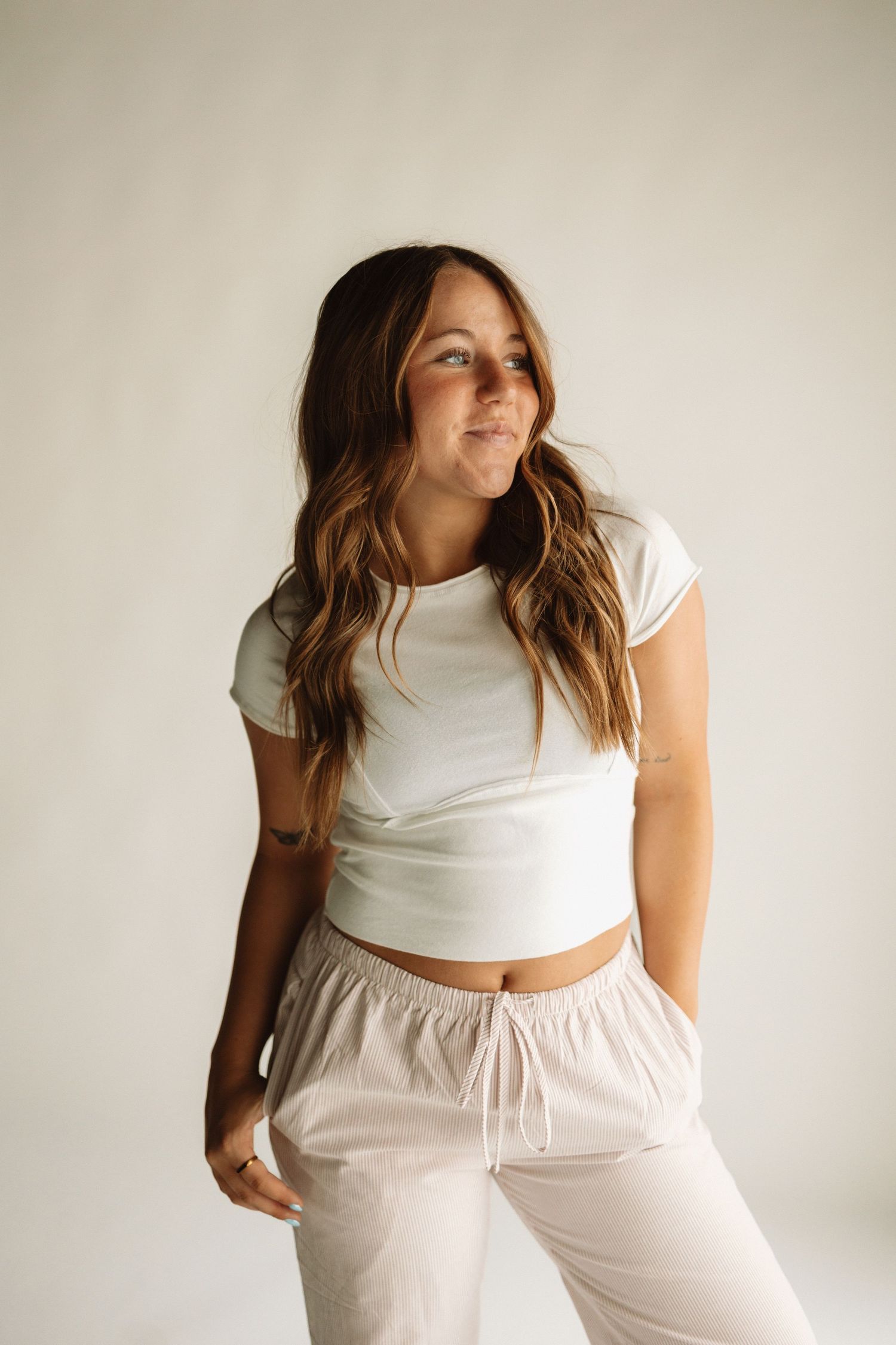A person in white loungewear poses against a white background in four different relaxed positions.