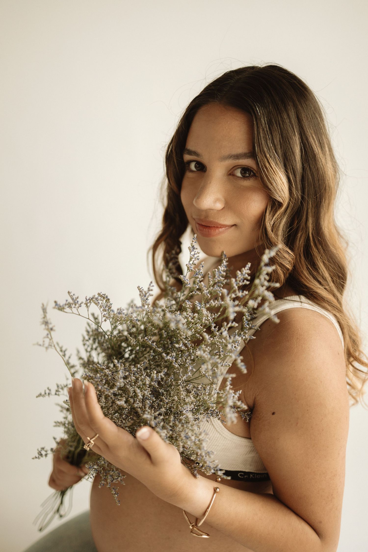 A series of intimate portrait shots featuring white baby's breath flowers held against a light neutral background.