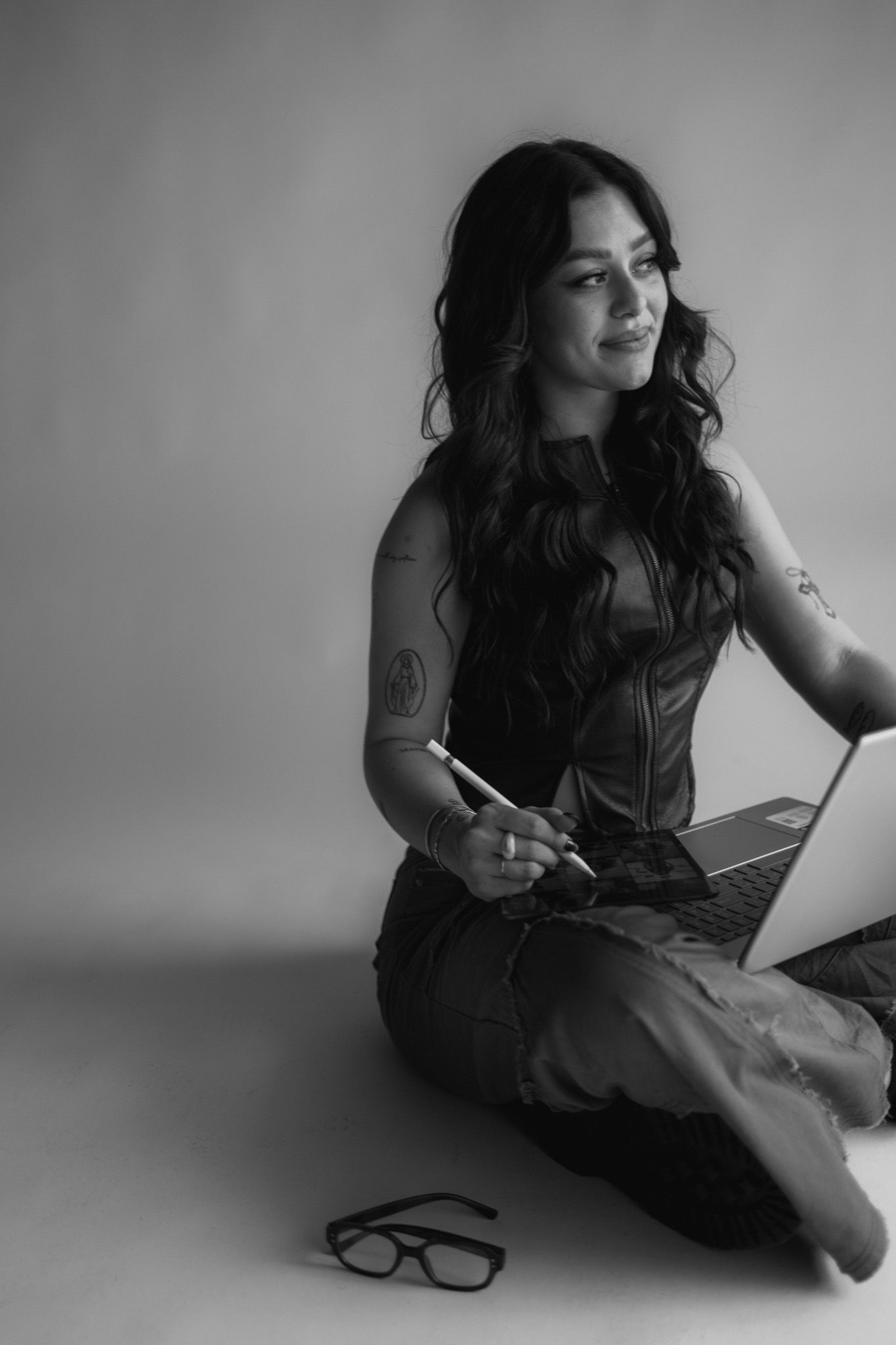 A series of black and white photos showing someone sitting on the floor writing or sketching in a notebook.
