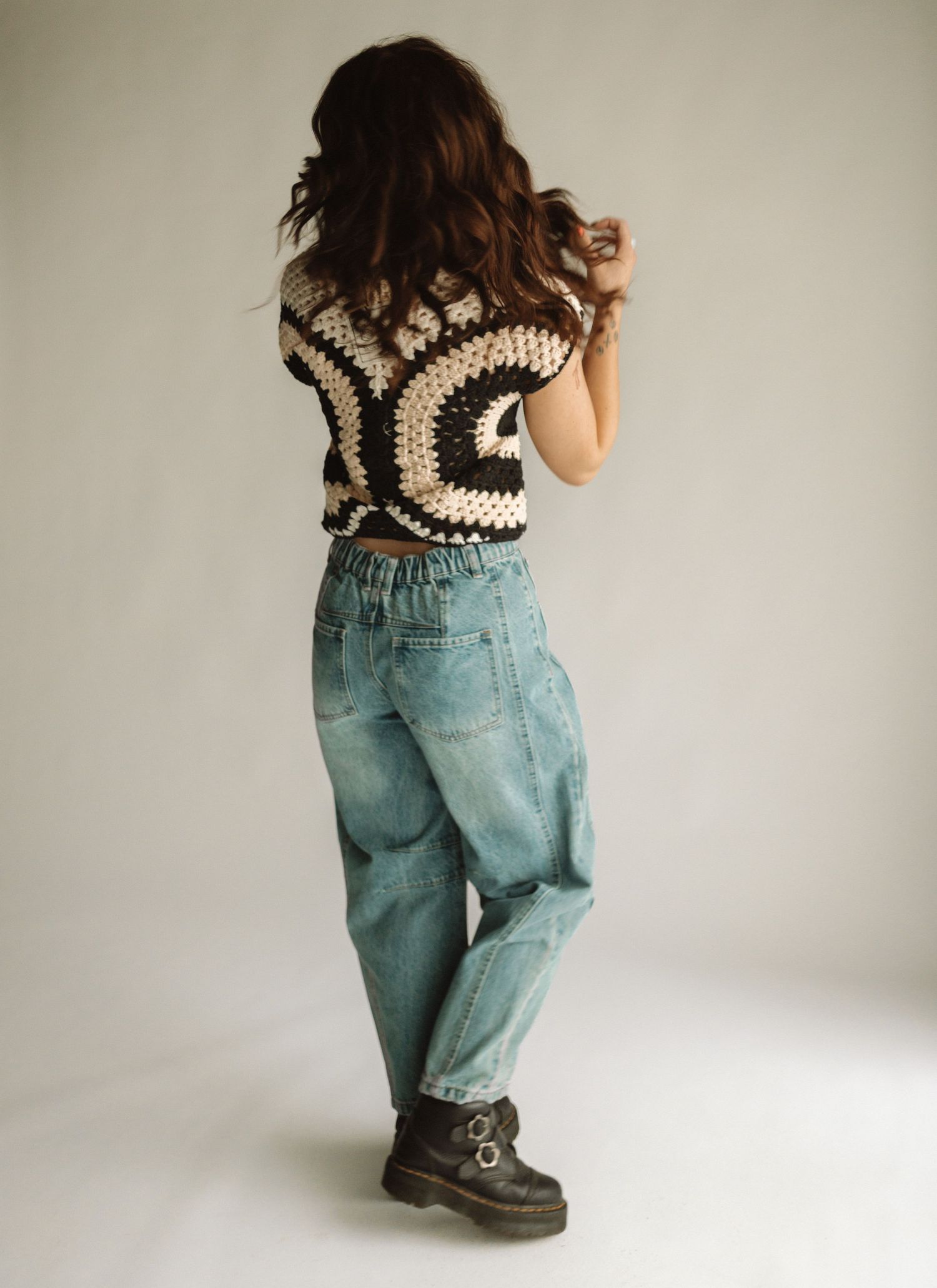 A series of photos showing light denim baggy jeans and crochet crop top modeled from different back angles.