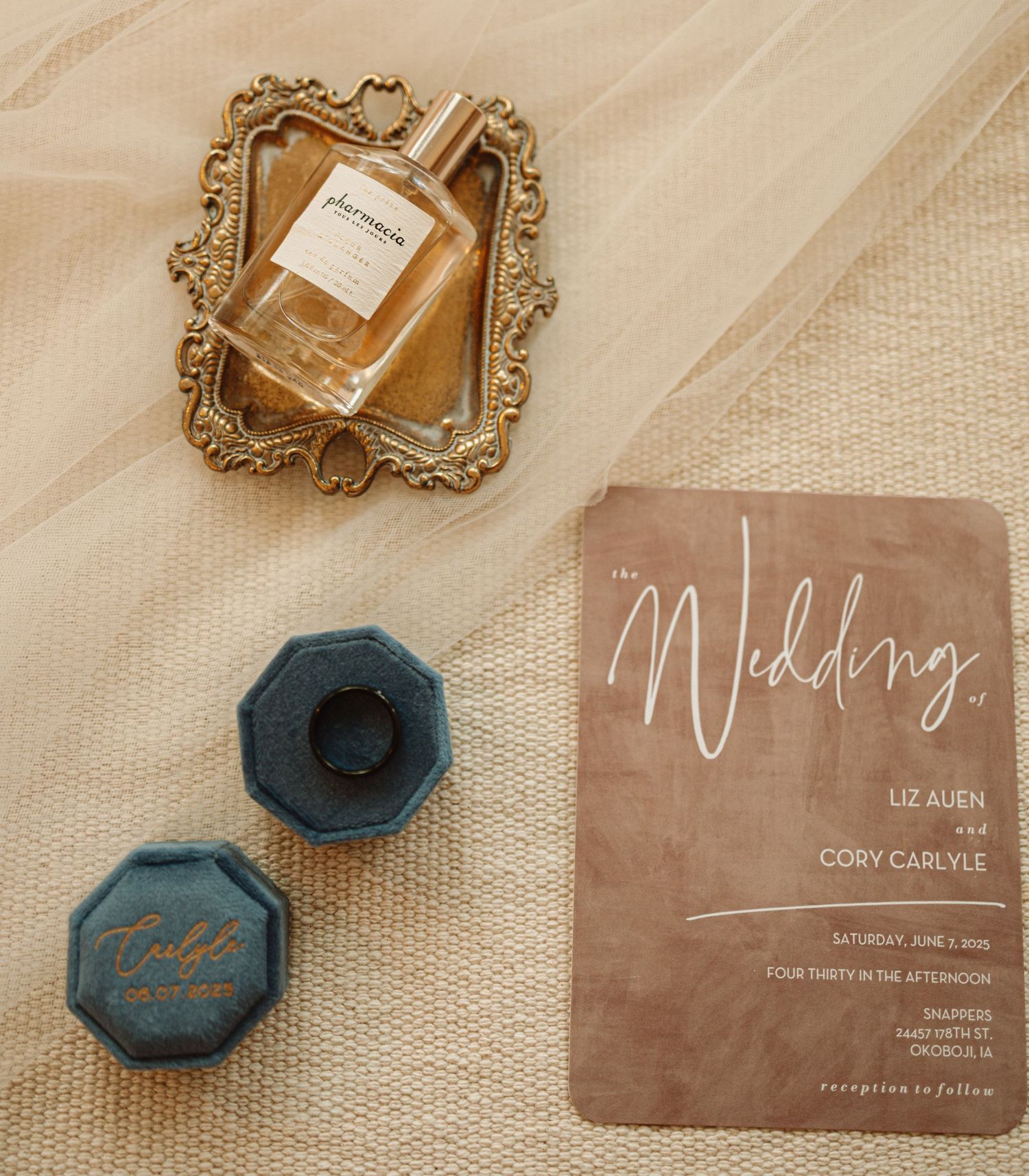 Close-up view of acrylic wedding invitations with blue agate stones and metallic detailing in rose gold against beige background.