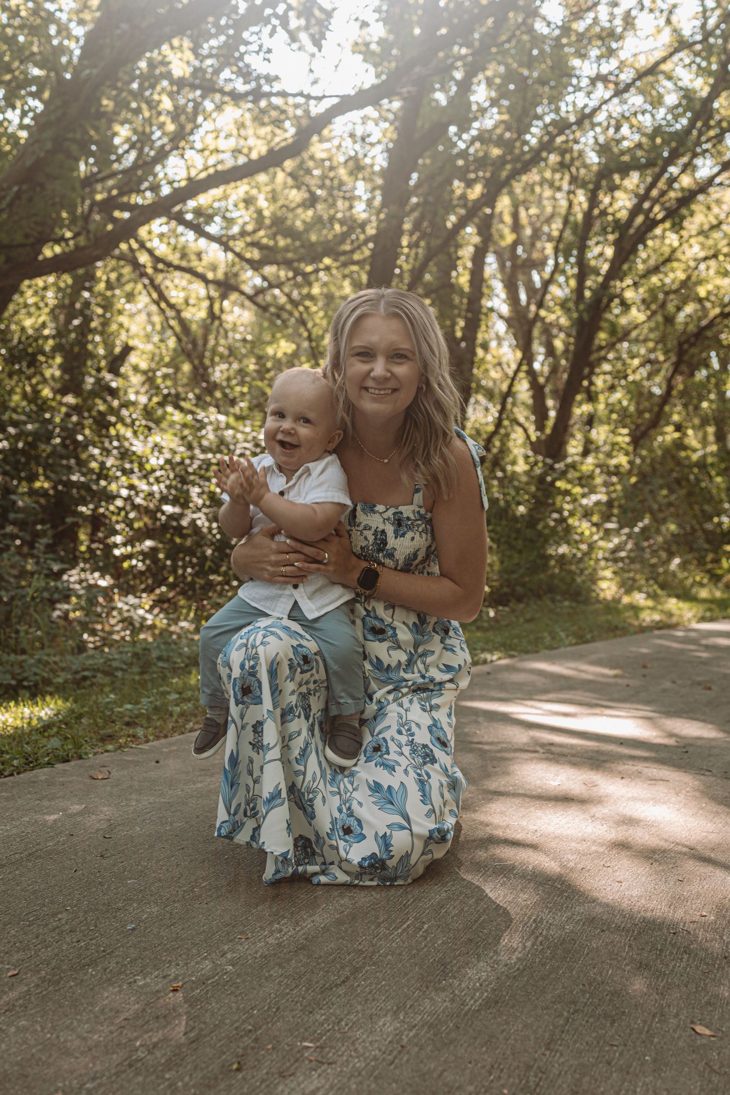 A joyful moment captured on a sunlit path with coordinating blue and white floral dresses.