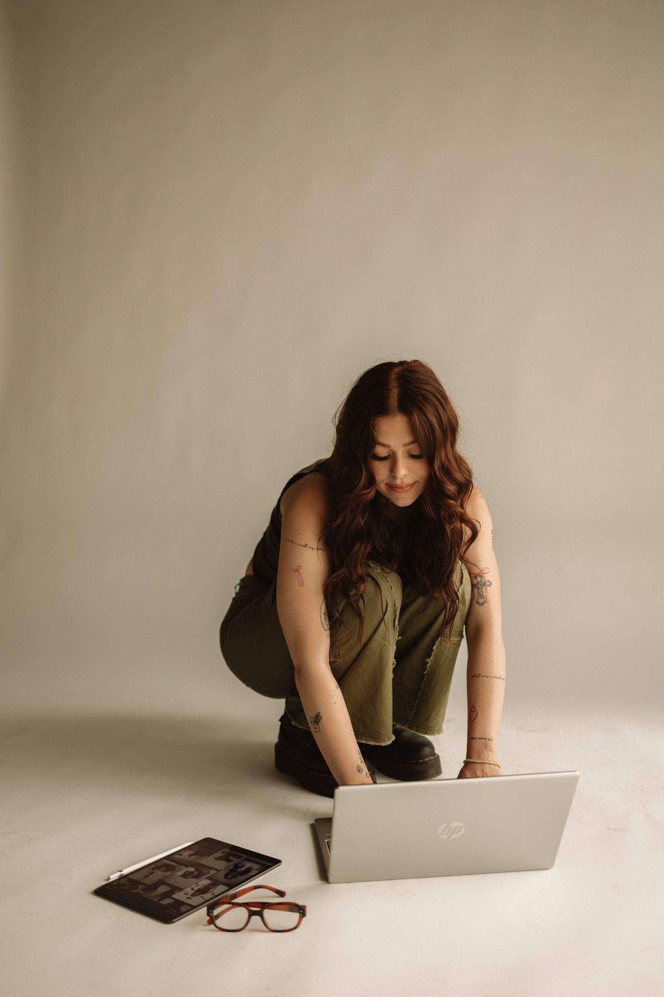 A photographer reviews images on a laptop while working in a studio setting.