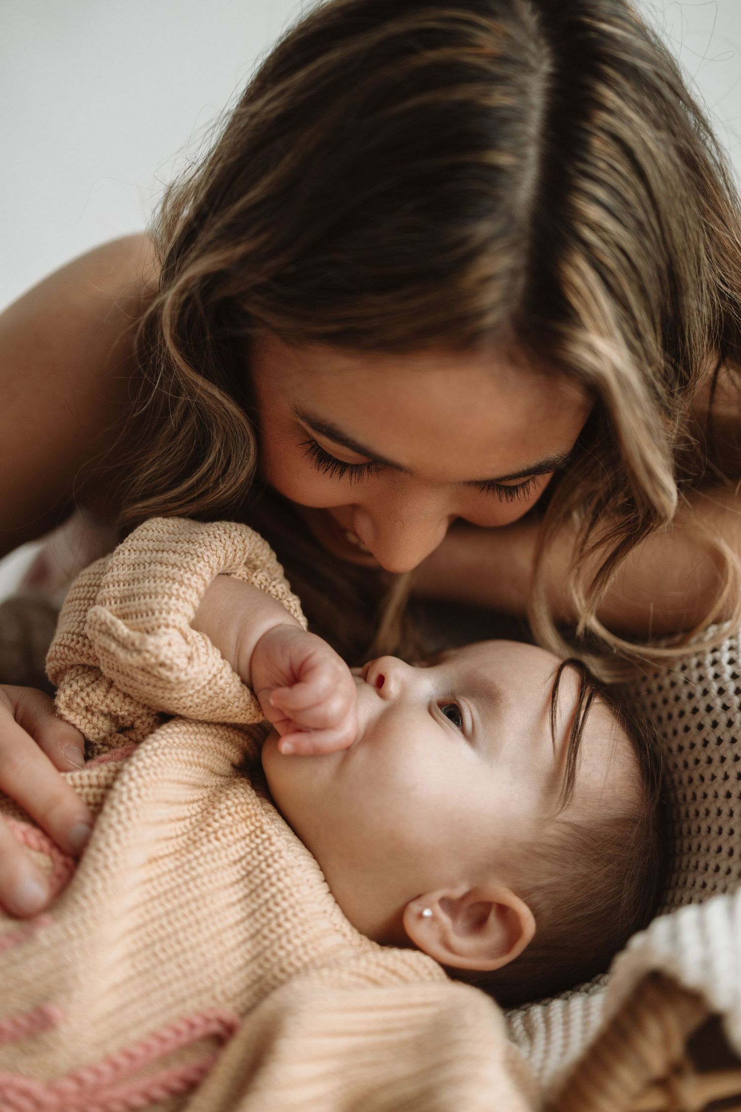 A tender moment of affection between a parent and child in matching beige sweaters.