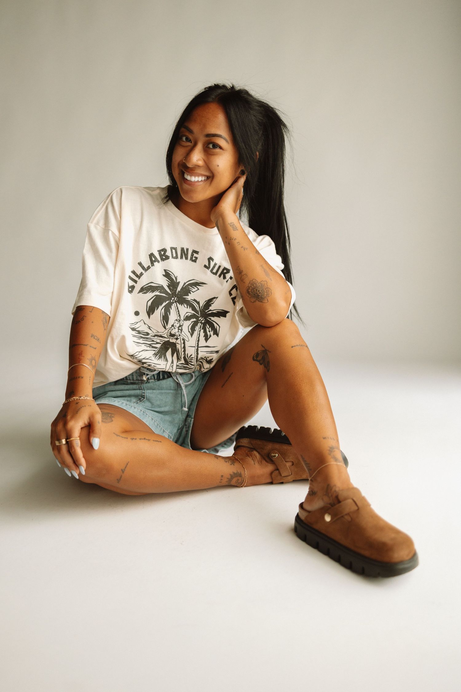 Series of lifestyle photos showing a relaxed pose wearing a white graphic t-shirt with palm trees and brown suede boots.