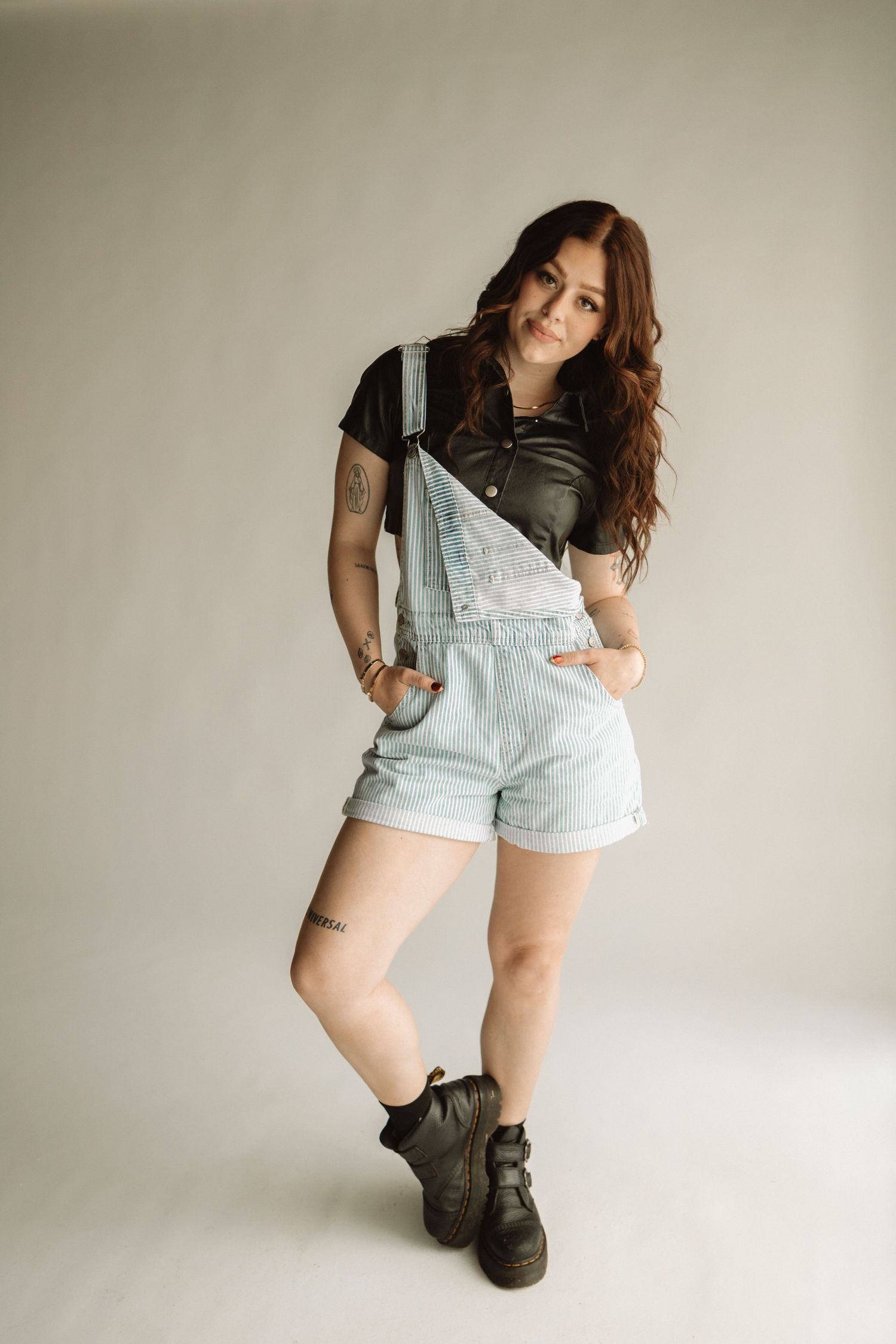 A figure in light blue overalls and a white shirt poses against a neutral wall, showing different angles and poses.