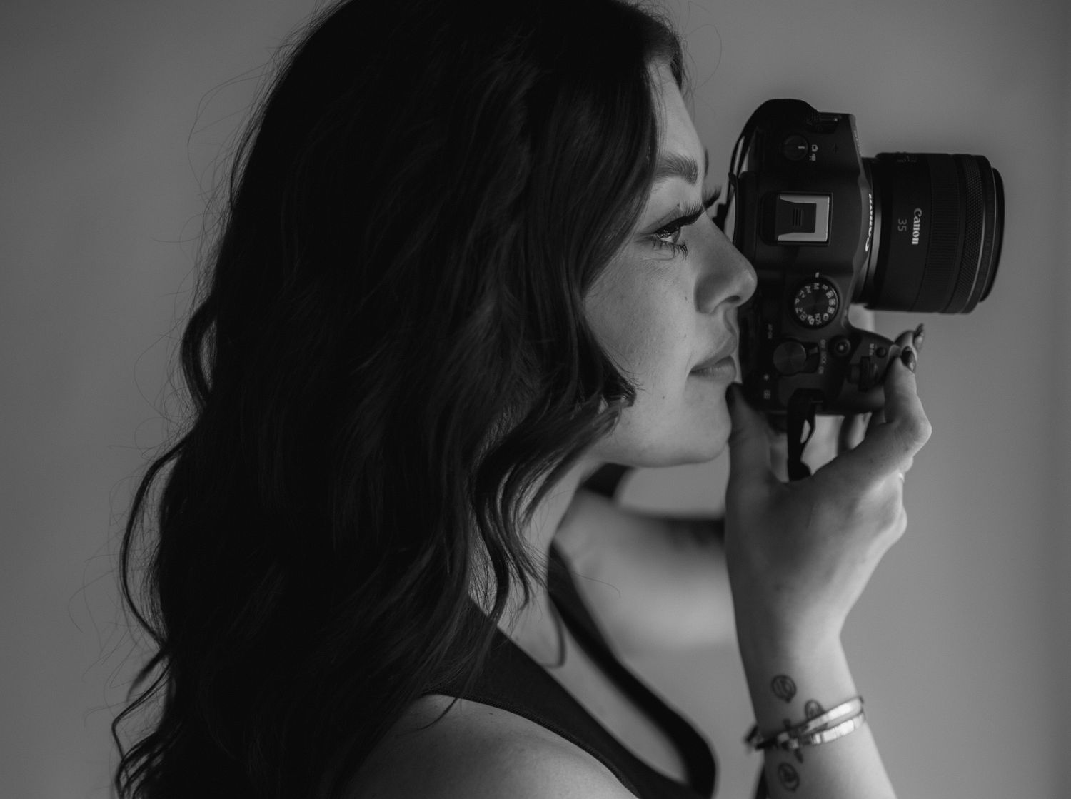 Side profile of photographer taking picture with professional camera in black and white.