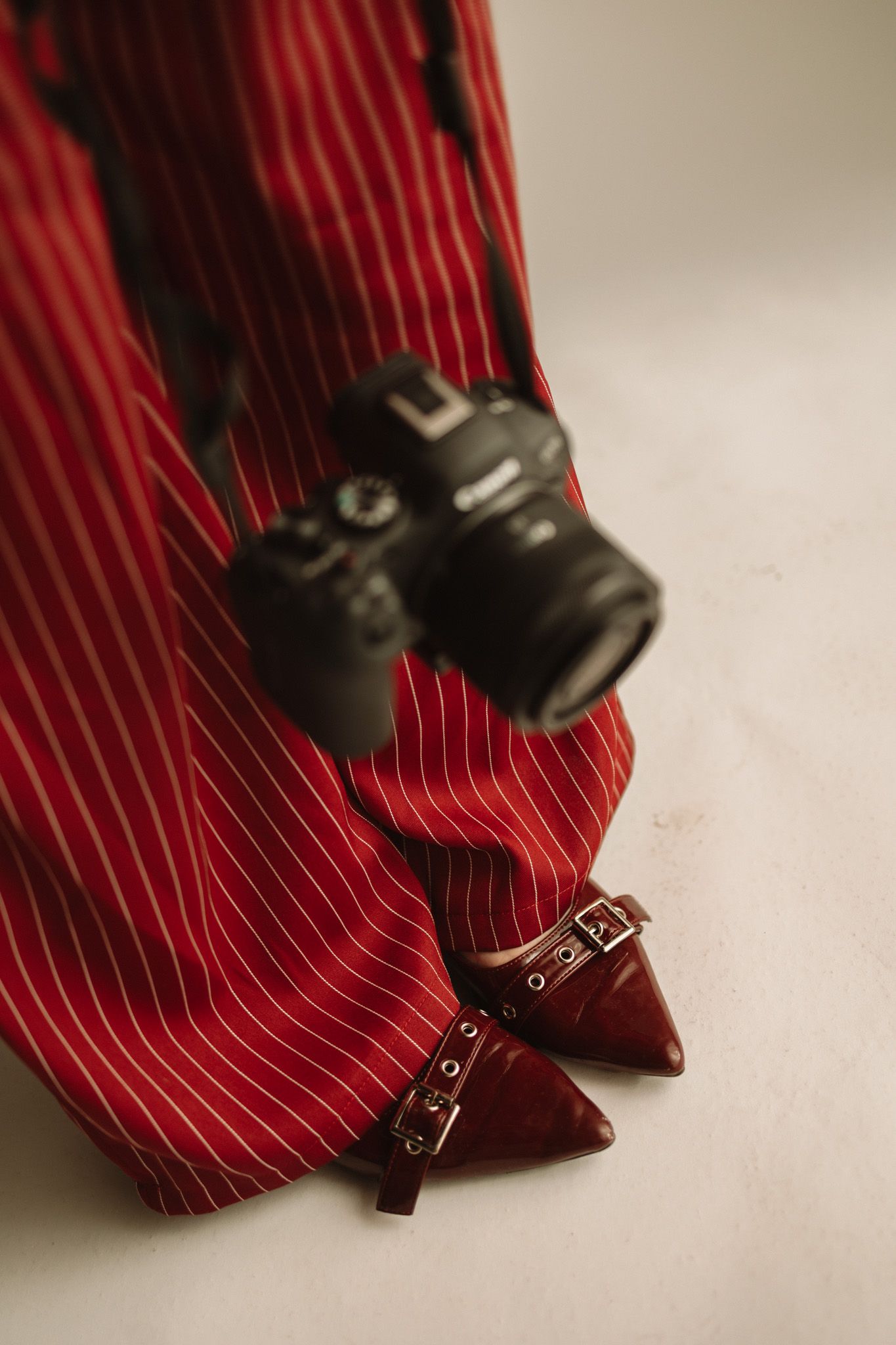 Close-up series of a red striped tie being rolled up, showing progressive stages of the rolling motion.
