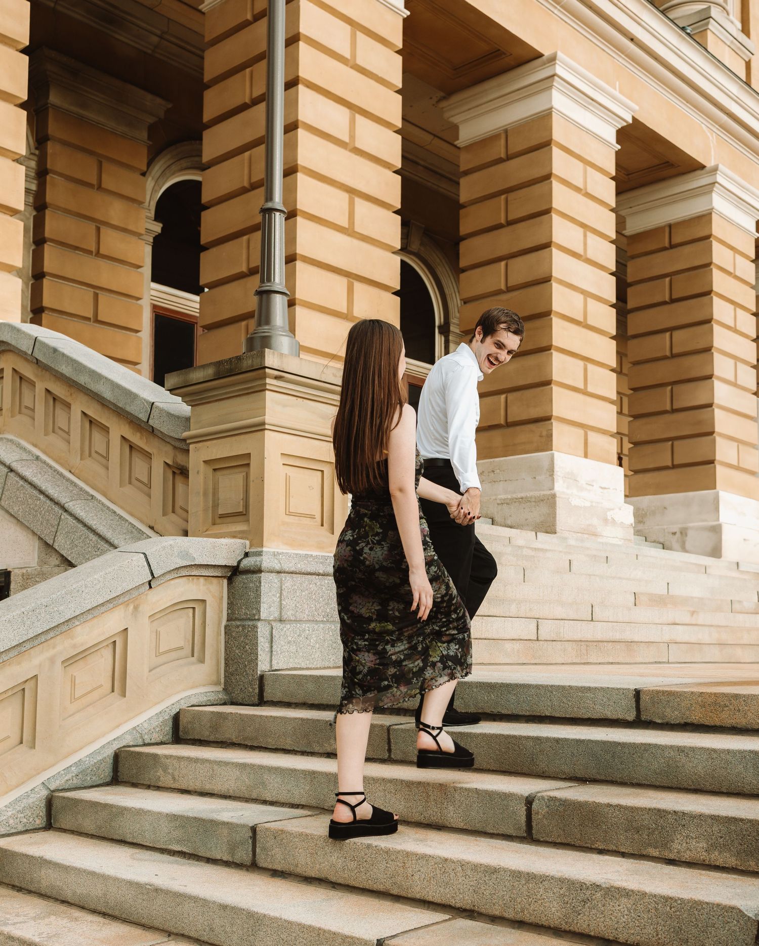 Four sequential photos showing someone sitting on stone steps outside a classical brick building with columns.