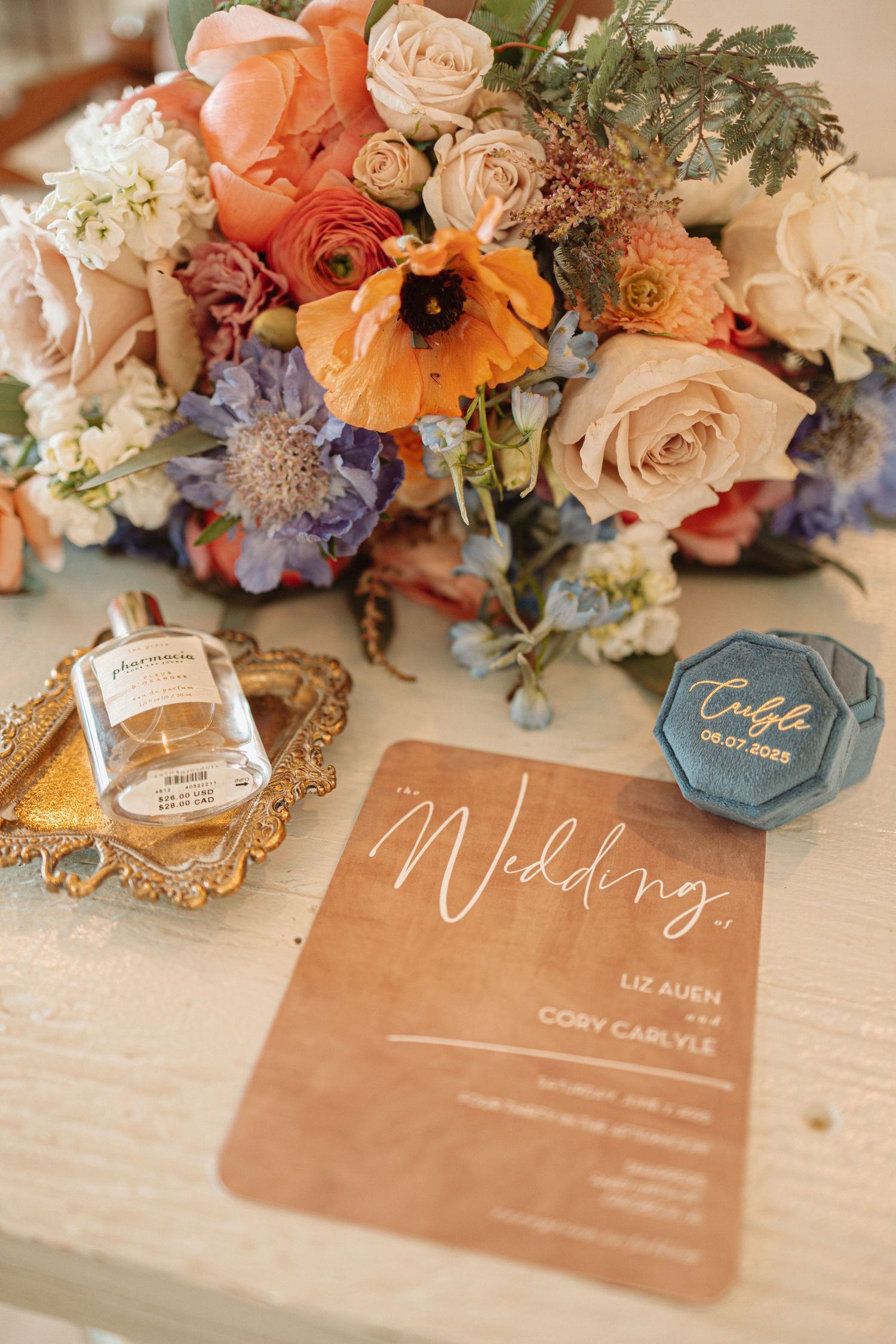 Wedding table place cards with clear acrylic and blue accents surrounded by coral and peach floral arrangements.