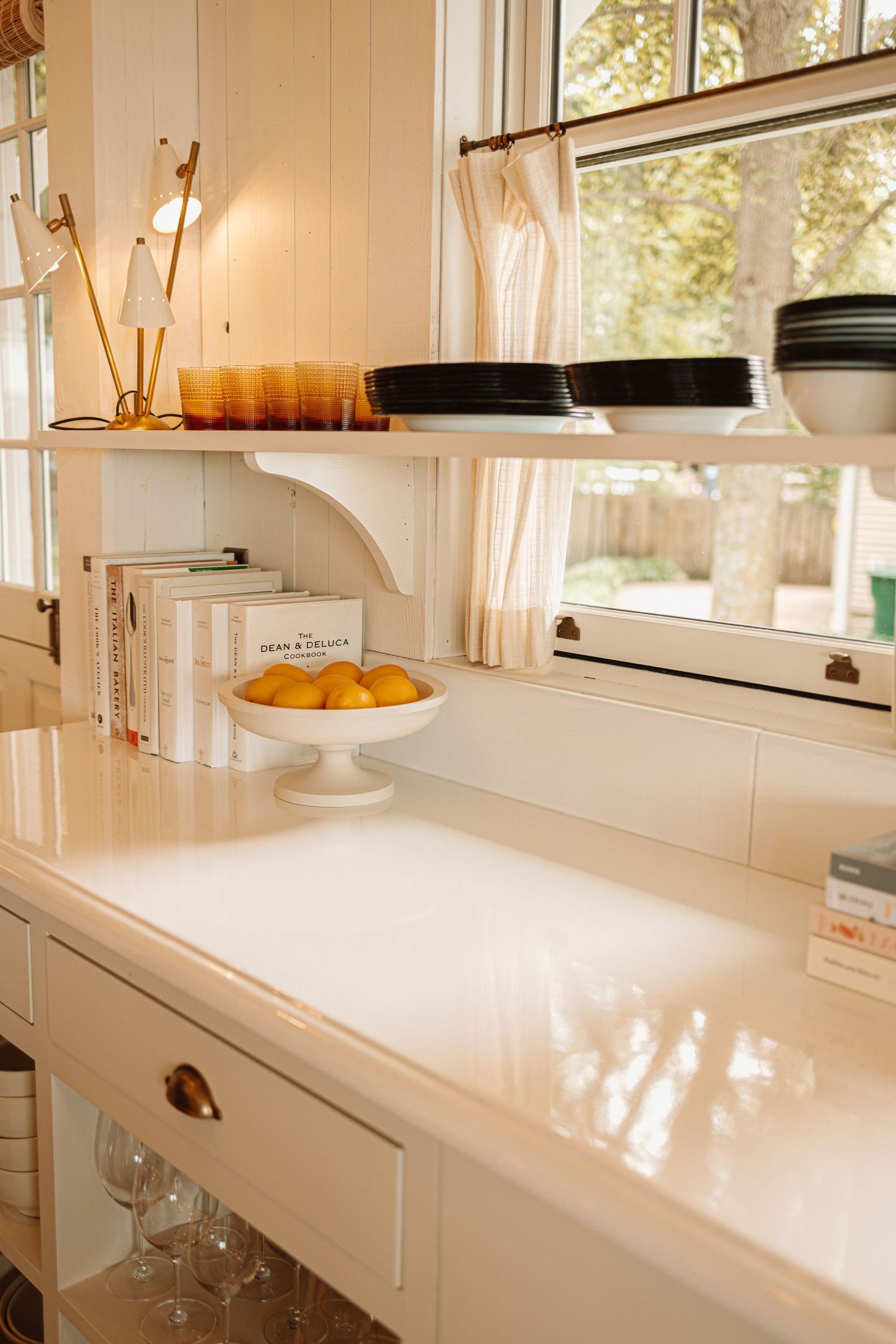 A bright white contemporary kitchen with marble countertops features clean lines and natural light streaming through windows.