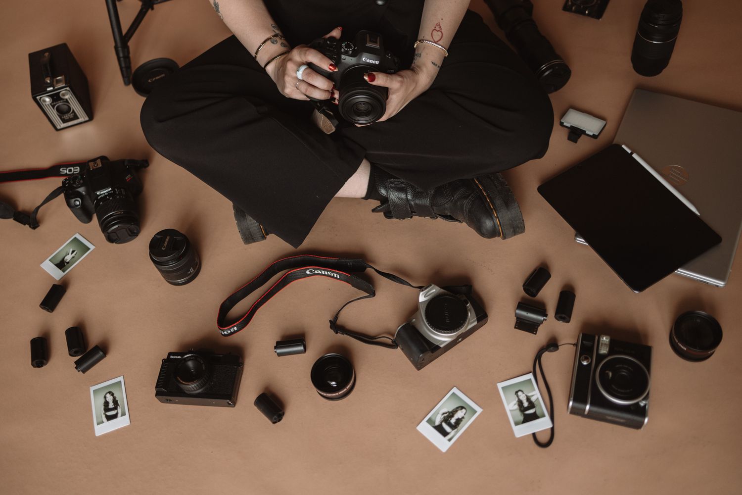 Overhead view of various photography equipment and accessories laid out on a dark surface.