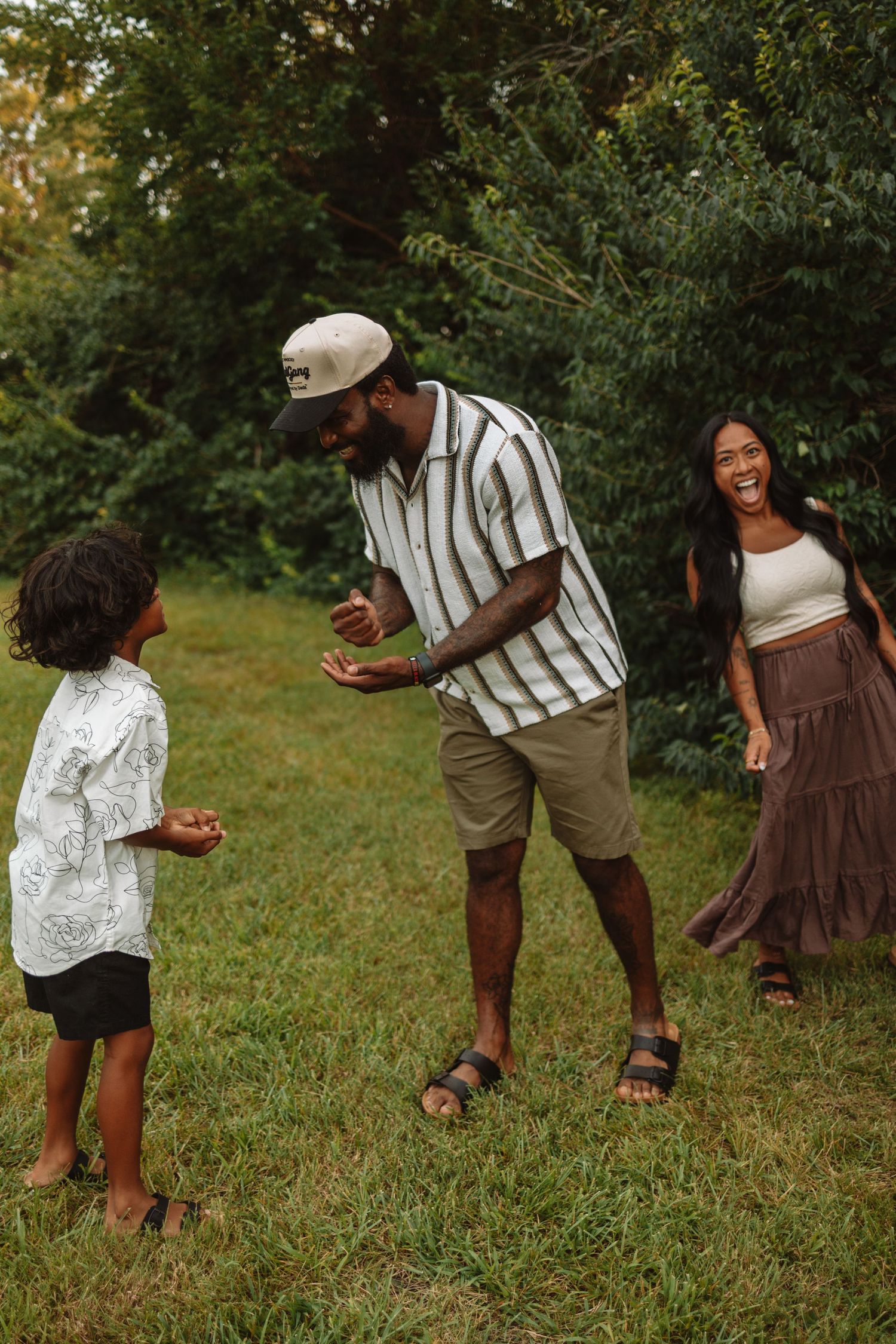 A sweet outdoor photography sequence showing tender moments between family members playing in a grassy field.