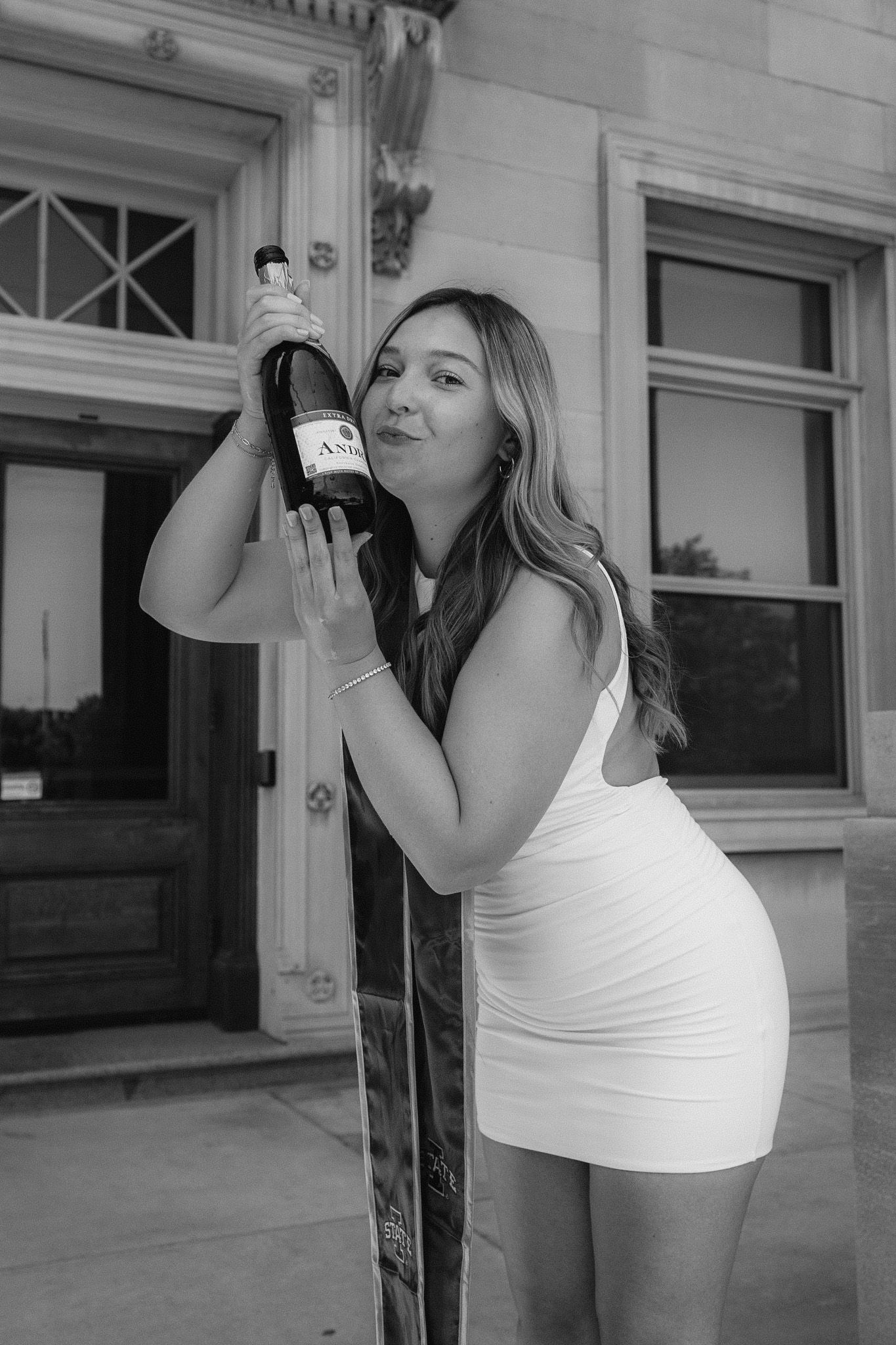 Black and white sequence of someone drinking from a bottle against a white wall.