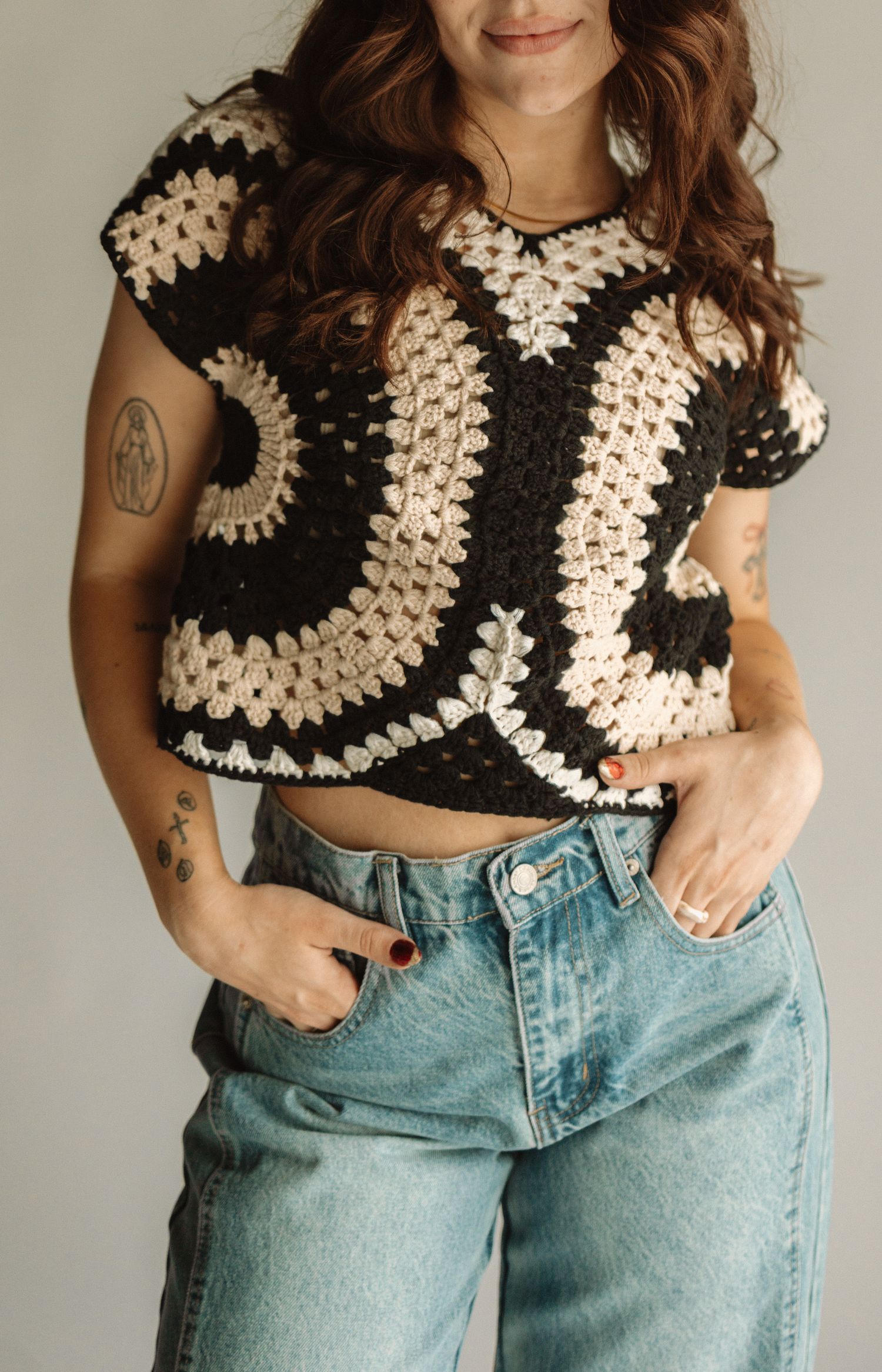 Crocheted cream and black granny square crop top paired with light wash vintage style jeans.