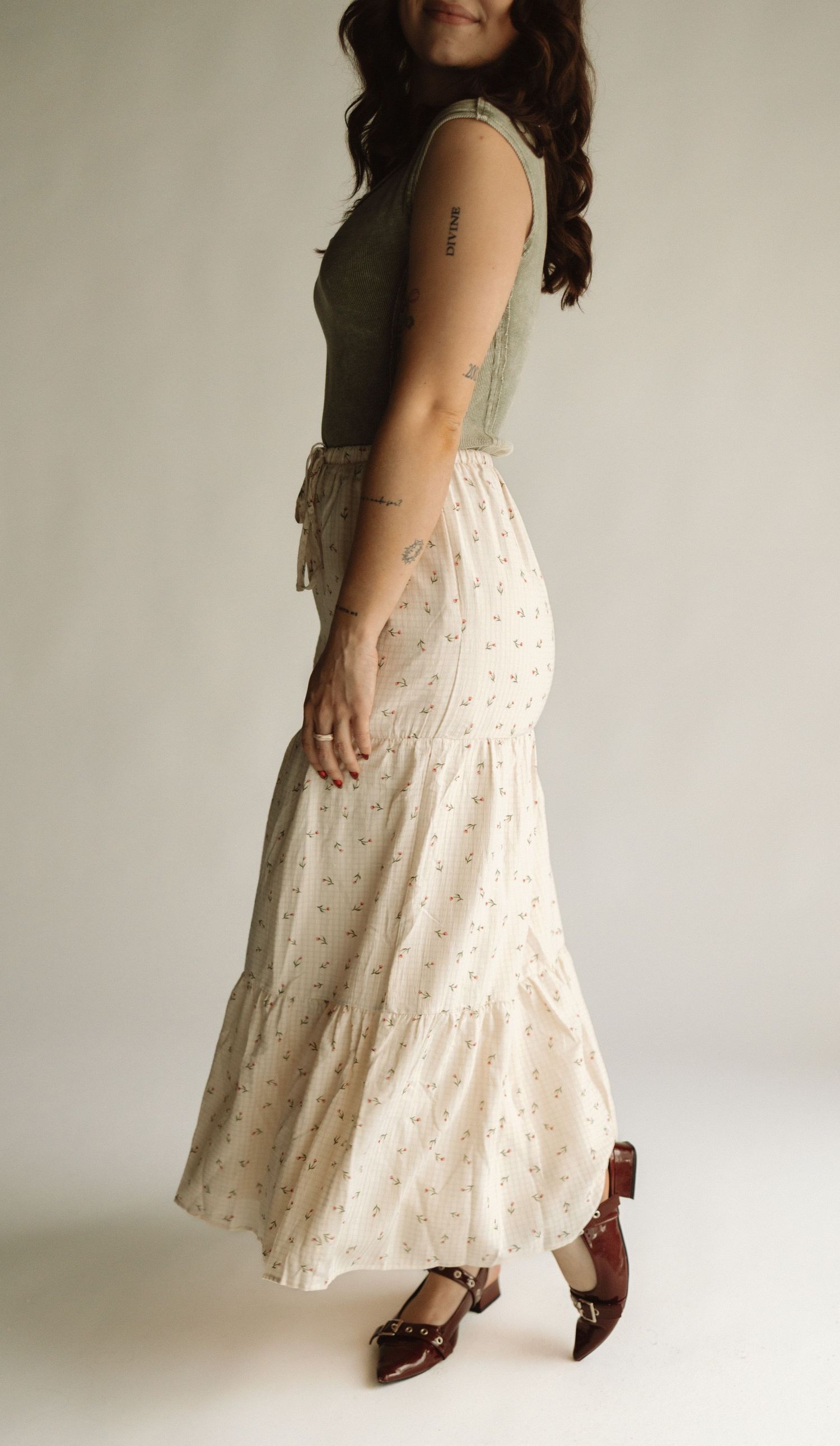 A person poses wearing a sleeveless floral dress and sandals while standing against a white background in four different views.