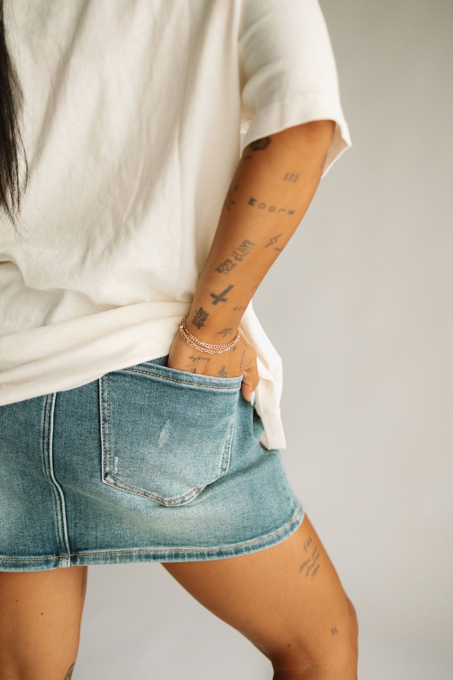 Close-up shots of a denim shorts on a person wearing a white t-shirt, showing multiple angles of the garment fit.