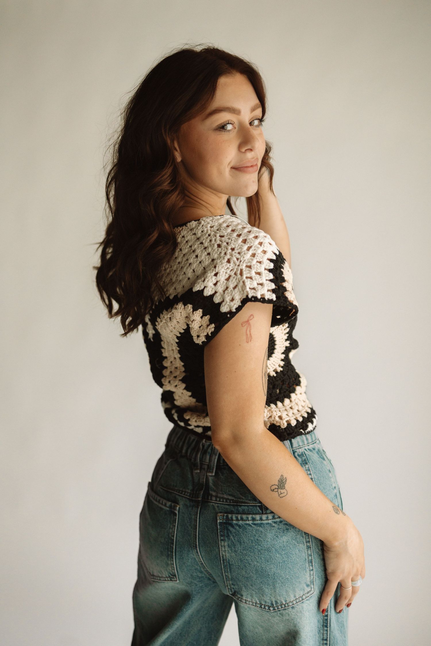 Person wearing vintage-style crocheted collar accessory with blue denim overalls in a series of styled poses.