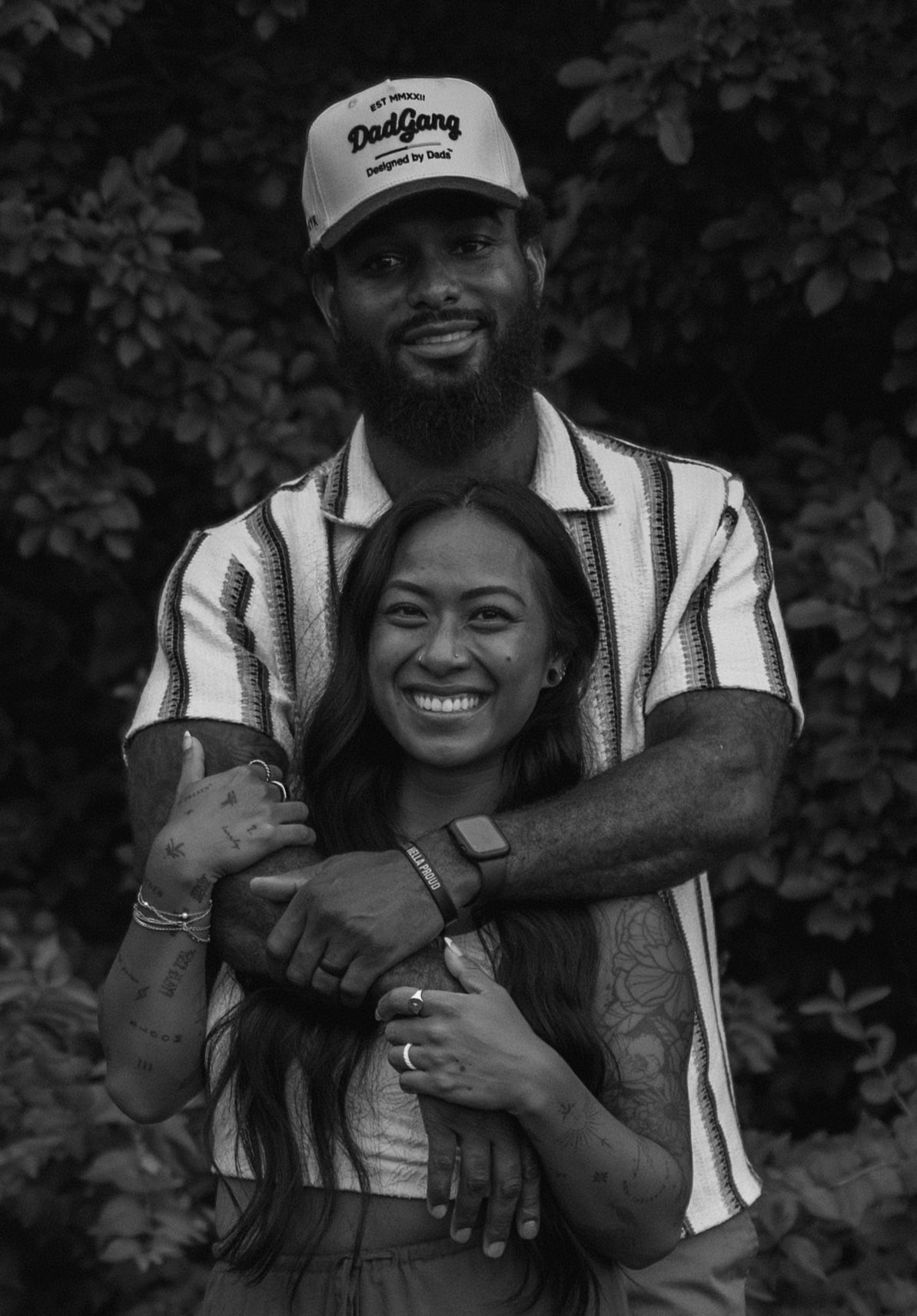 A romantic black and white photo series showing a couple embracing and sharing joyful moments outdoors.