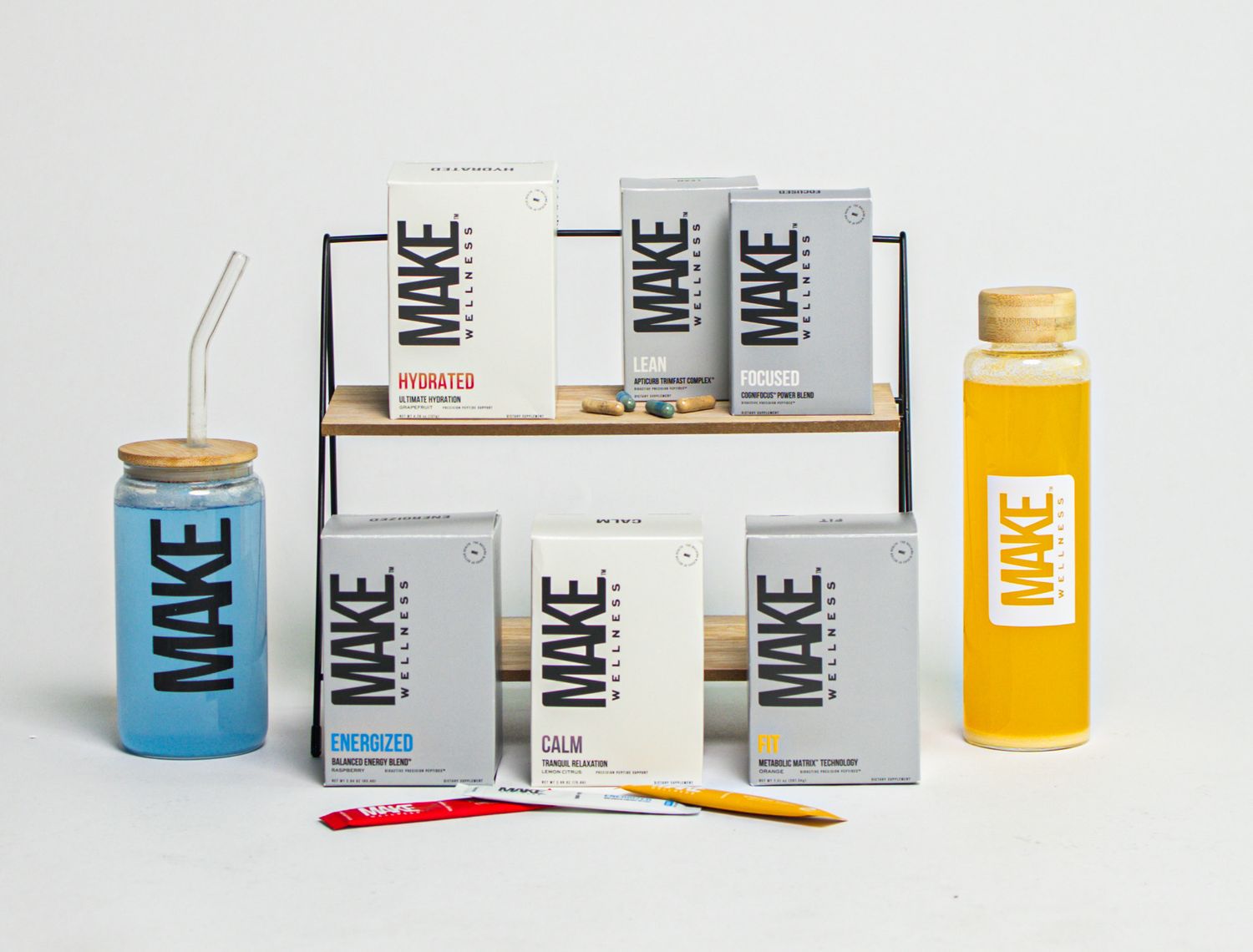 Modern minimalist skincare and wellness products displayed in white and blue packaging with orange accents.