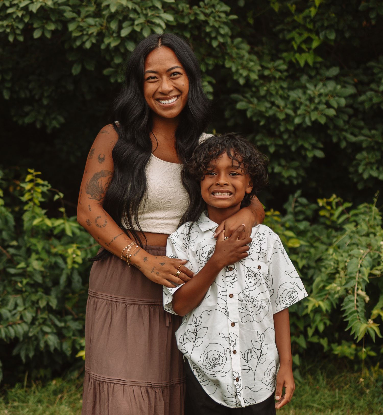A joyful outdoor portrait session in a lush green setting with casual summer outfits.