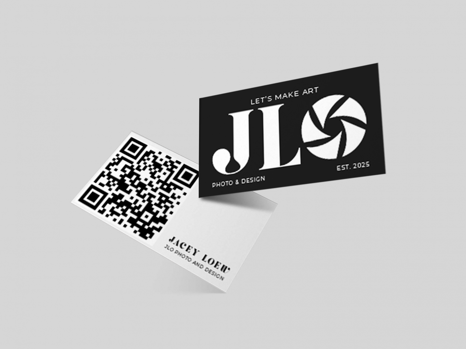 Black and white business cards featuring a photography logo design with JLD text and QR code laid on white surface.