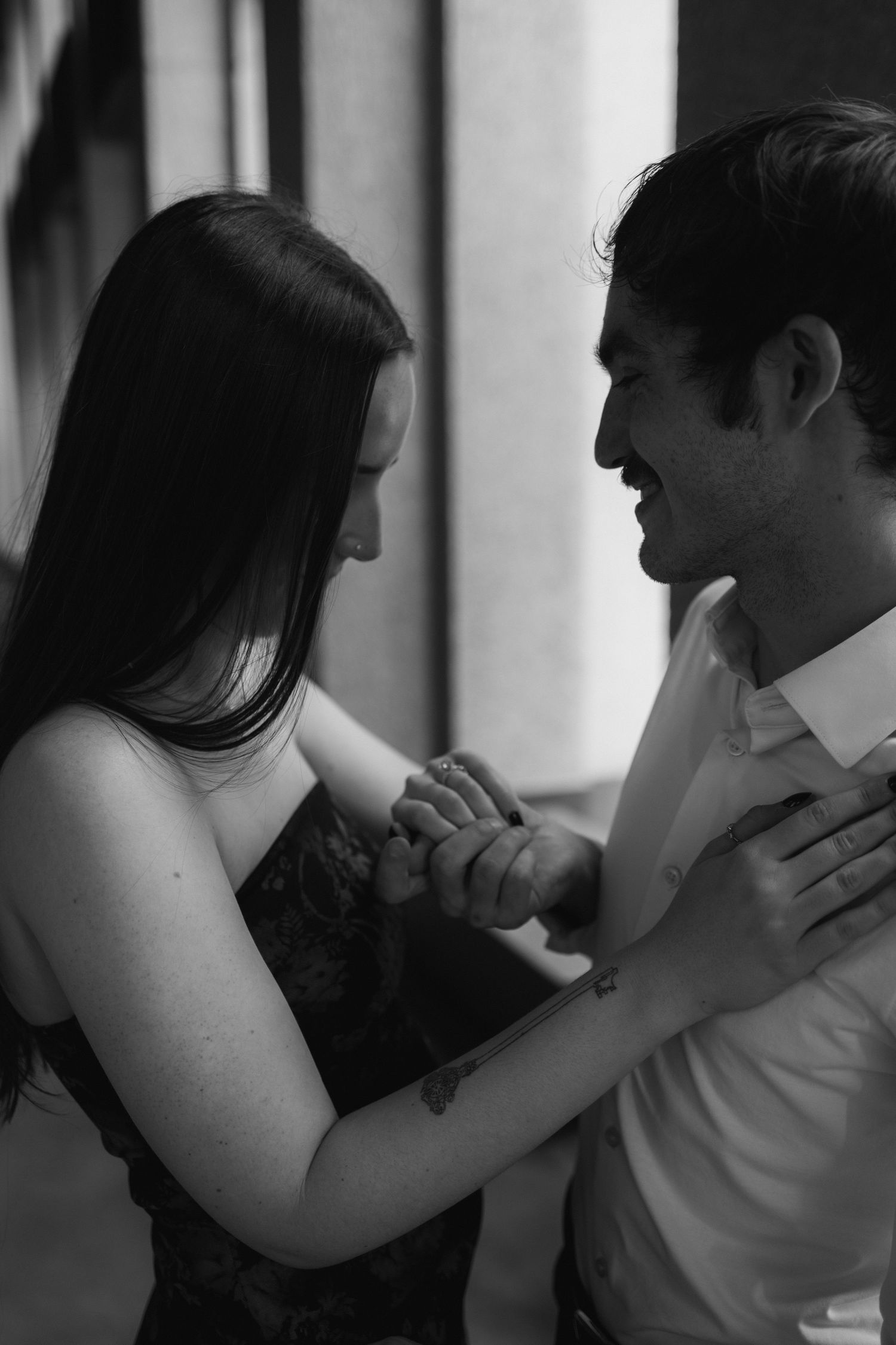 A romantic black and white photograph of a couple dancing intimately together in formal attire.