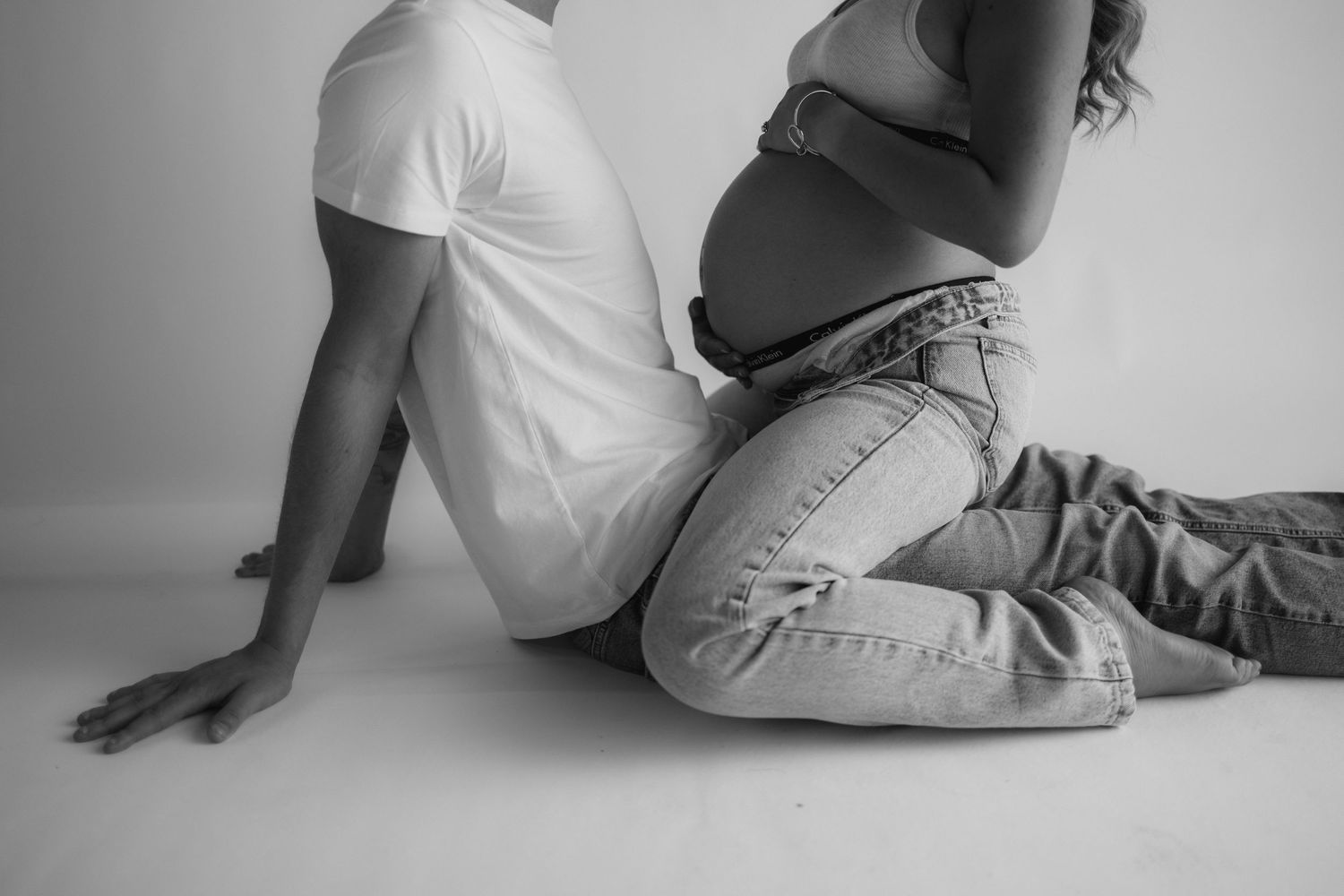 Black and white photo sequence showing someone sitting on floor and slowly lying down in a gradual progression.