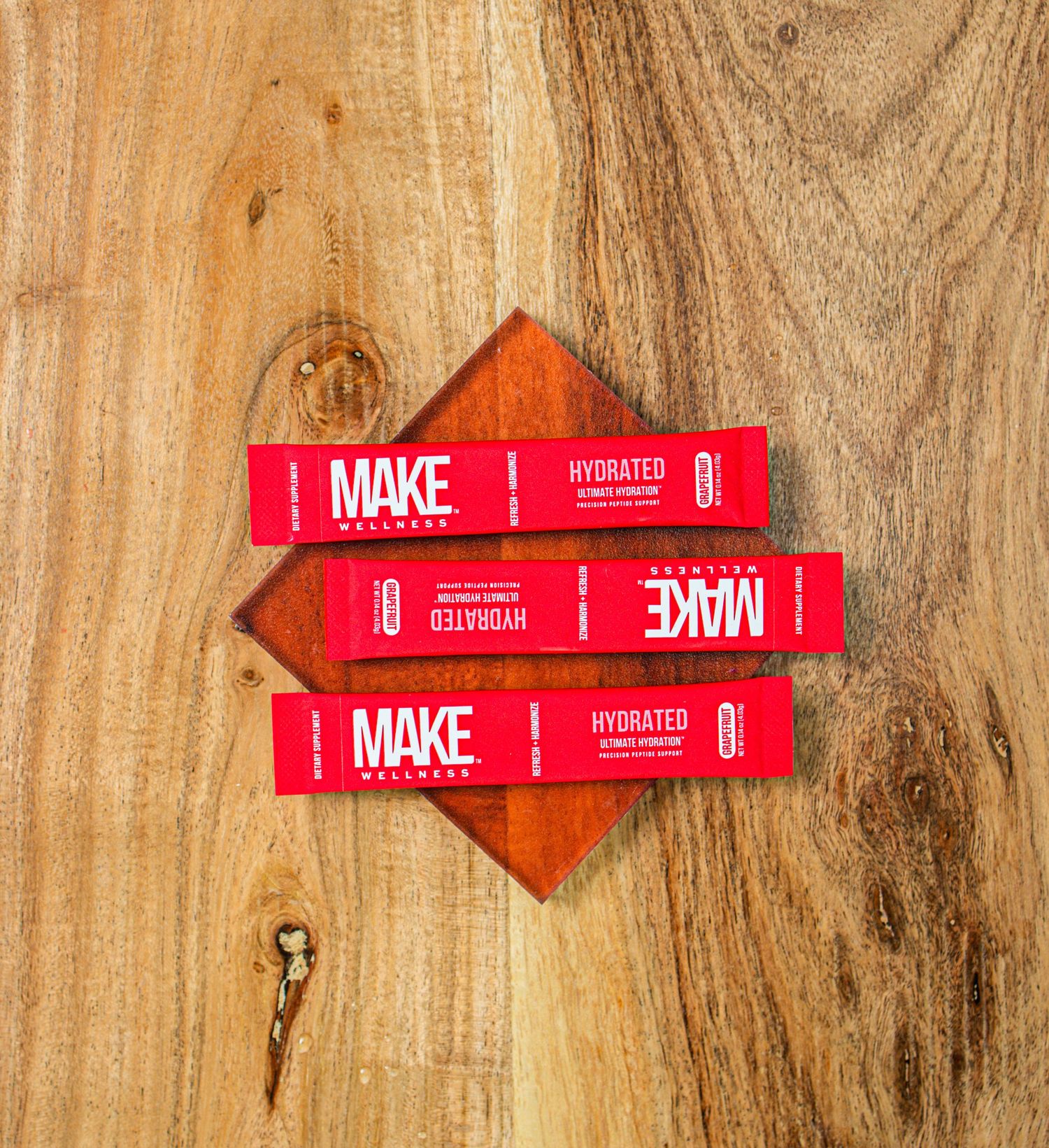 Red Make branded product tags displayed on a rustic wooden background.