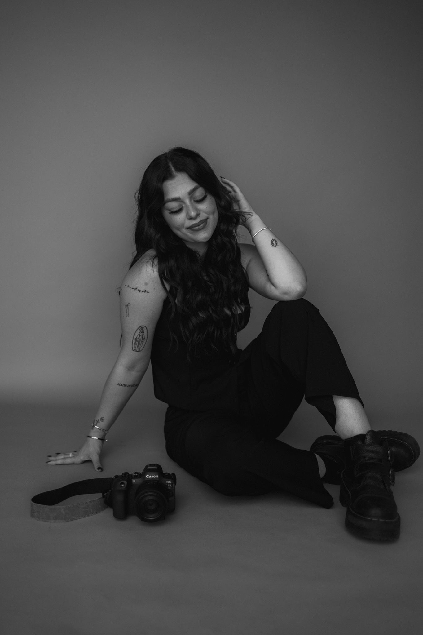 A series of artistic black and white photos showing a person in relaxed poses on the floor.