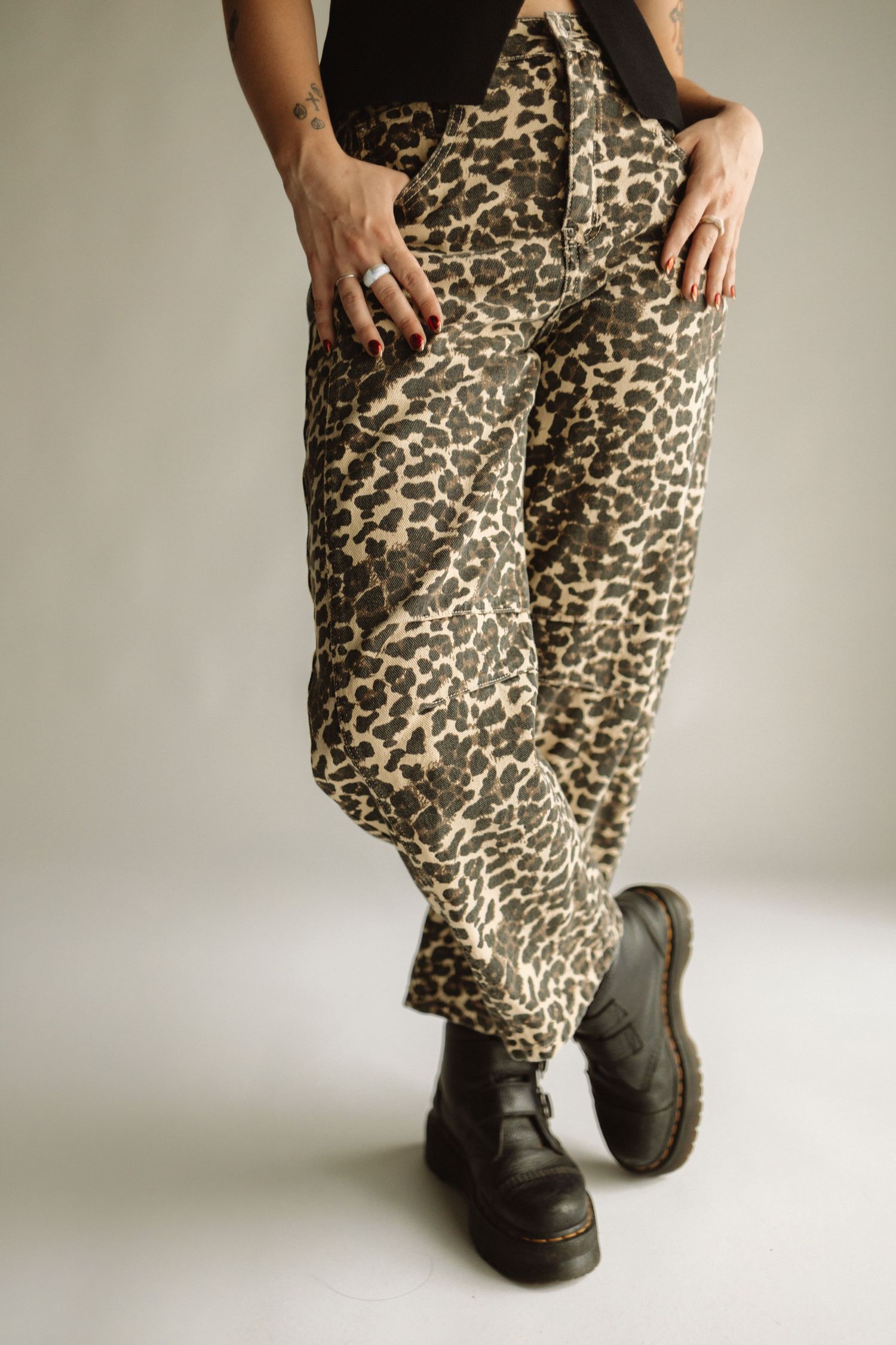 A close-up sequence showing leopard print pants and black shoes from different angles against a neutral background.