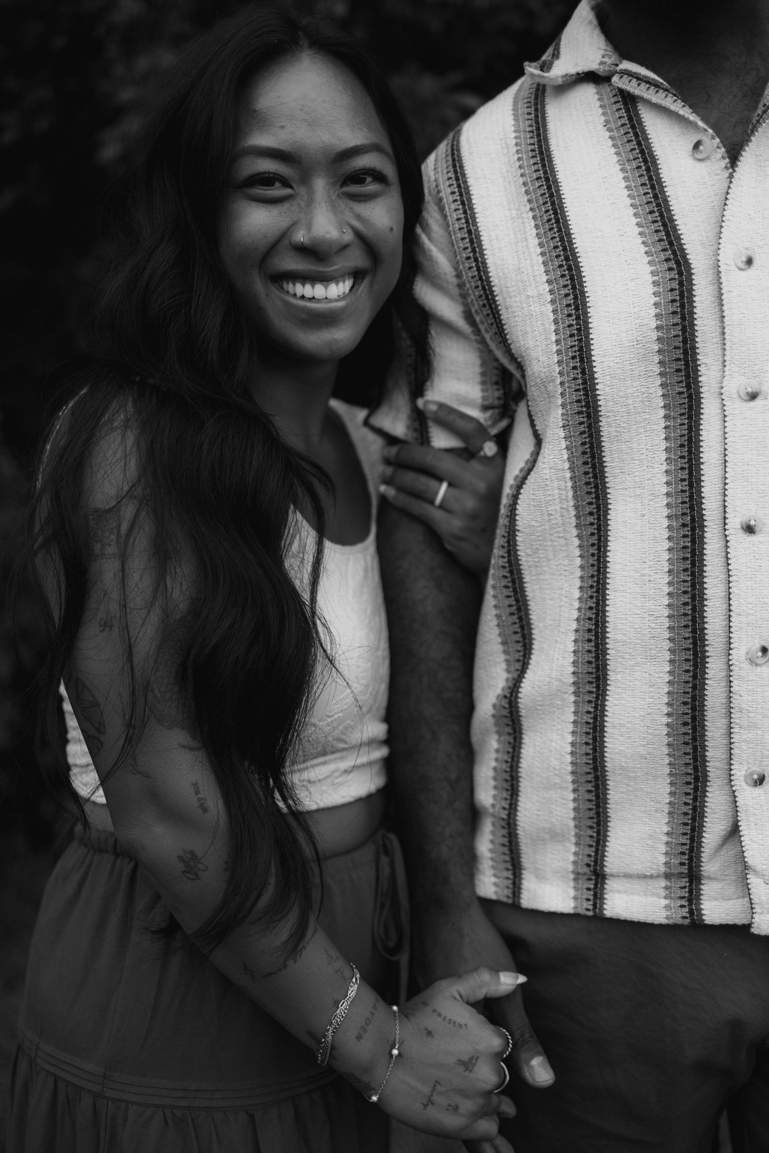 Black and white candid photo series showing a couple sharing joyful moments together in casual attire.
