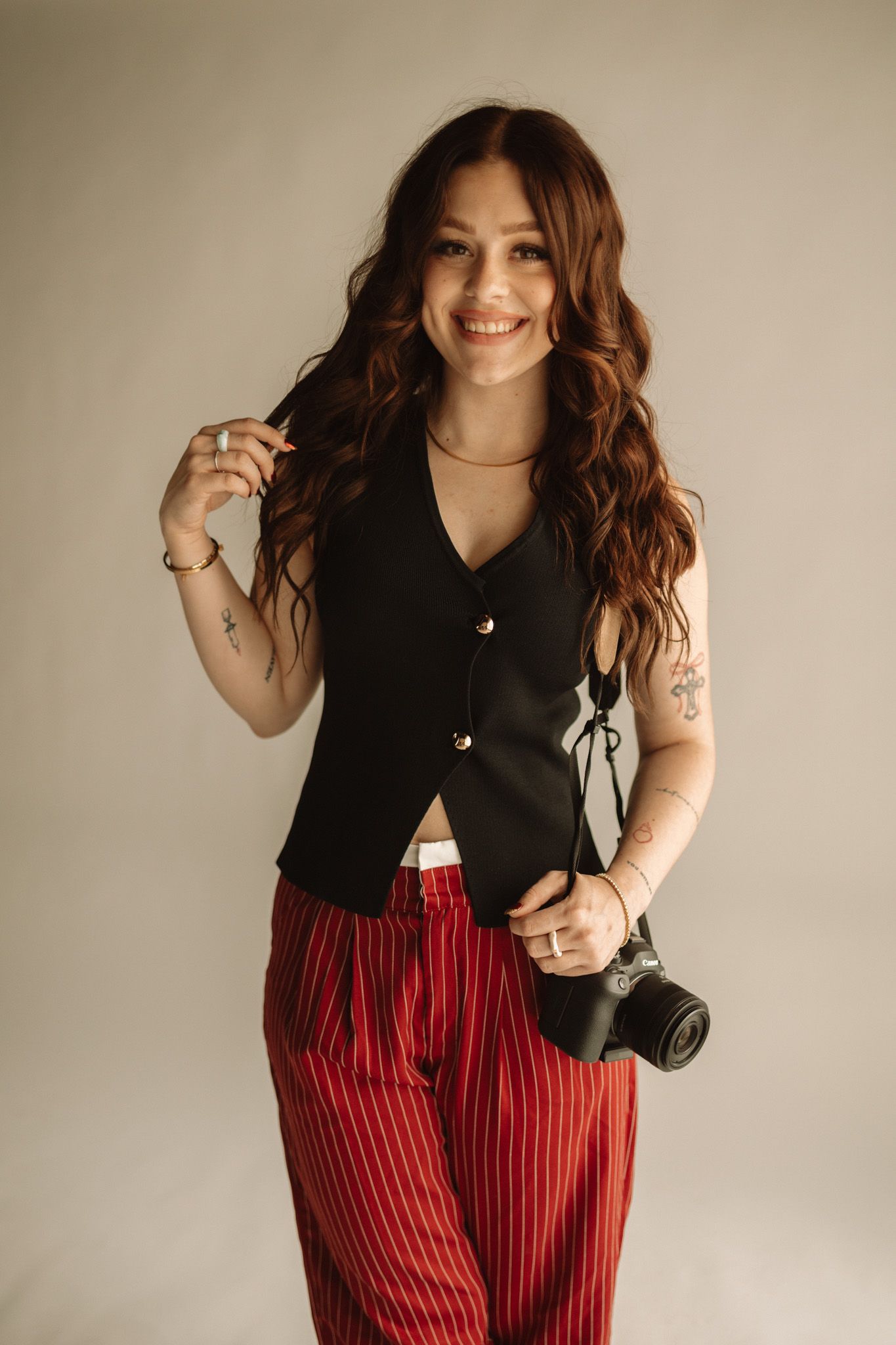 Fashion outfit featuring a black sleeveless top paired with red and black striped pants shown from multiple angles.