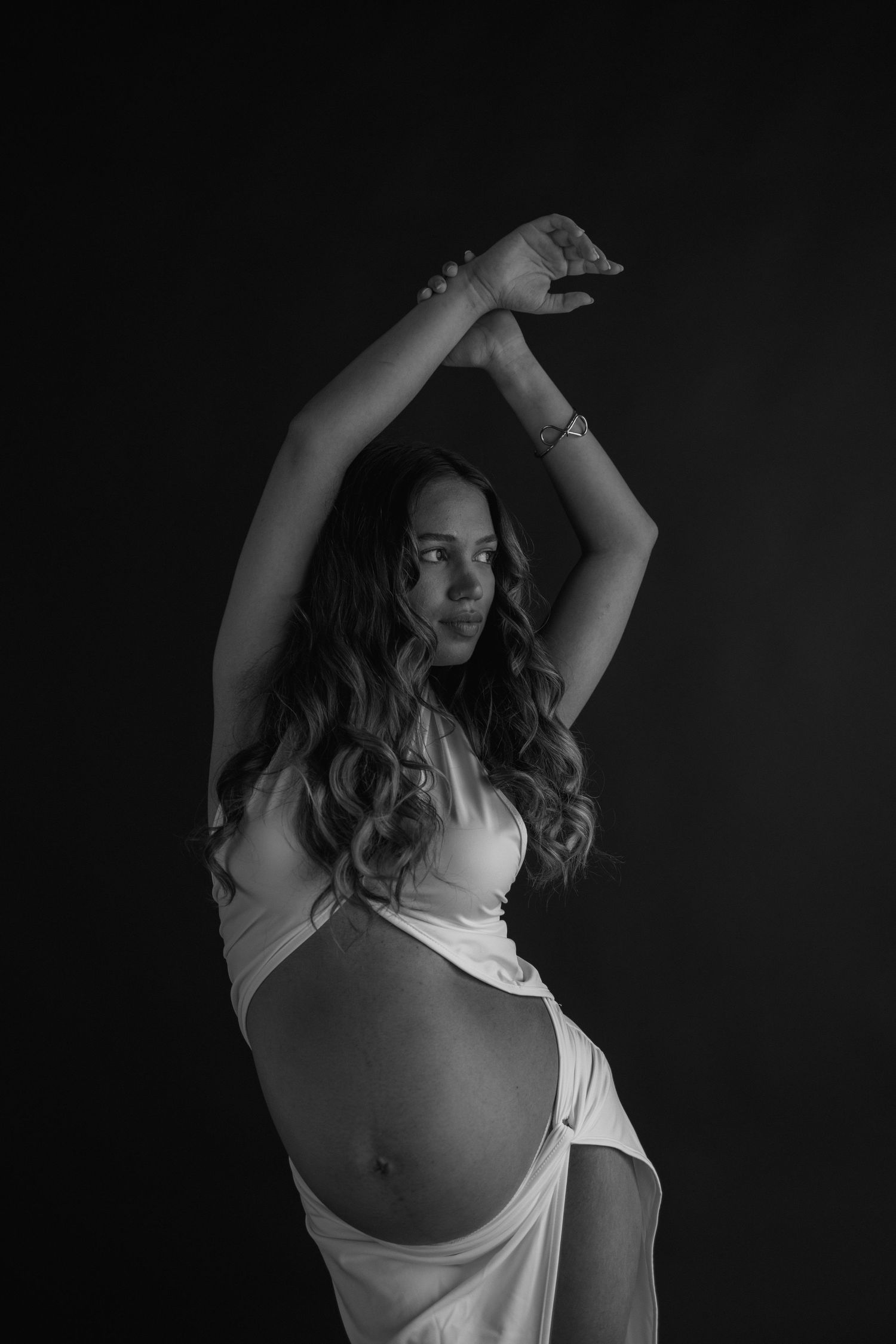 Black and white artistic portrait series showing movement with flowing white fabric and dark background.