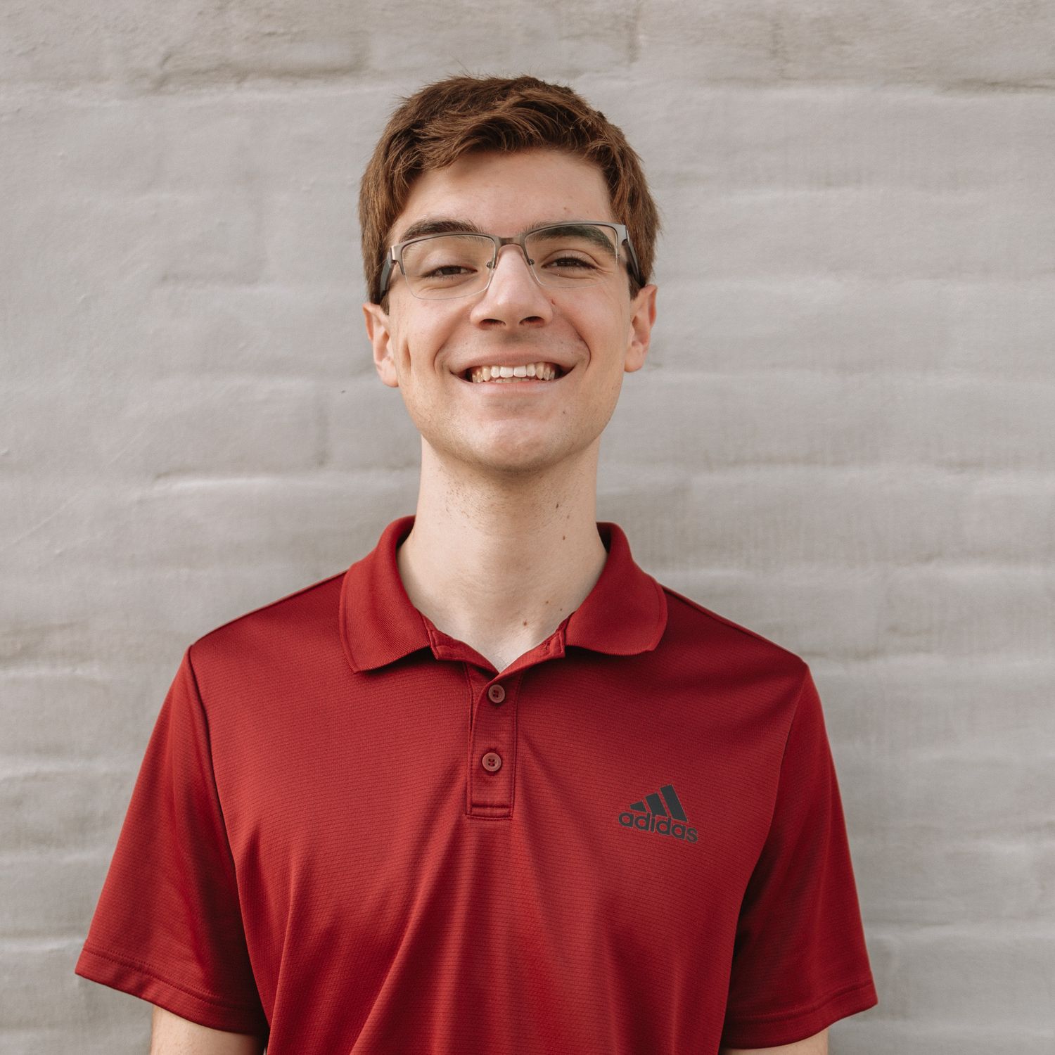 Portrait series of a person wearing a red polo shirt against a gray wall shown from different angles and expressions.