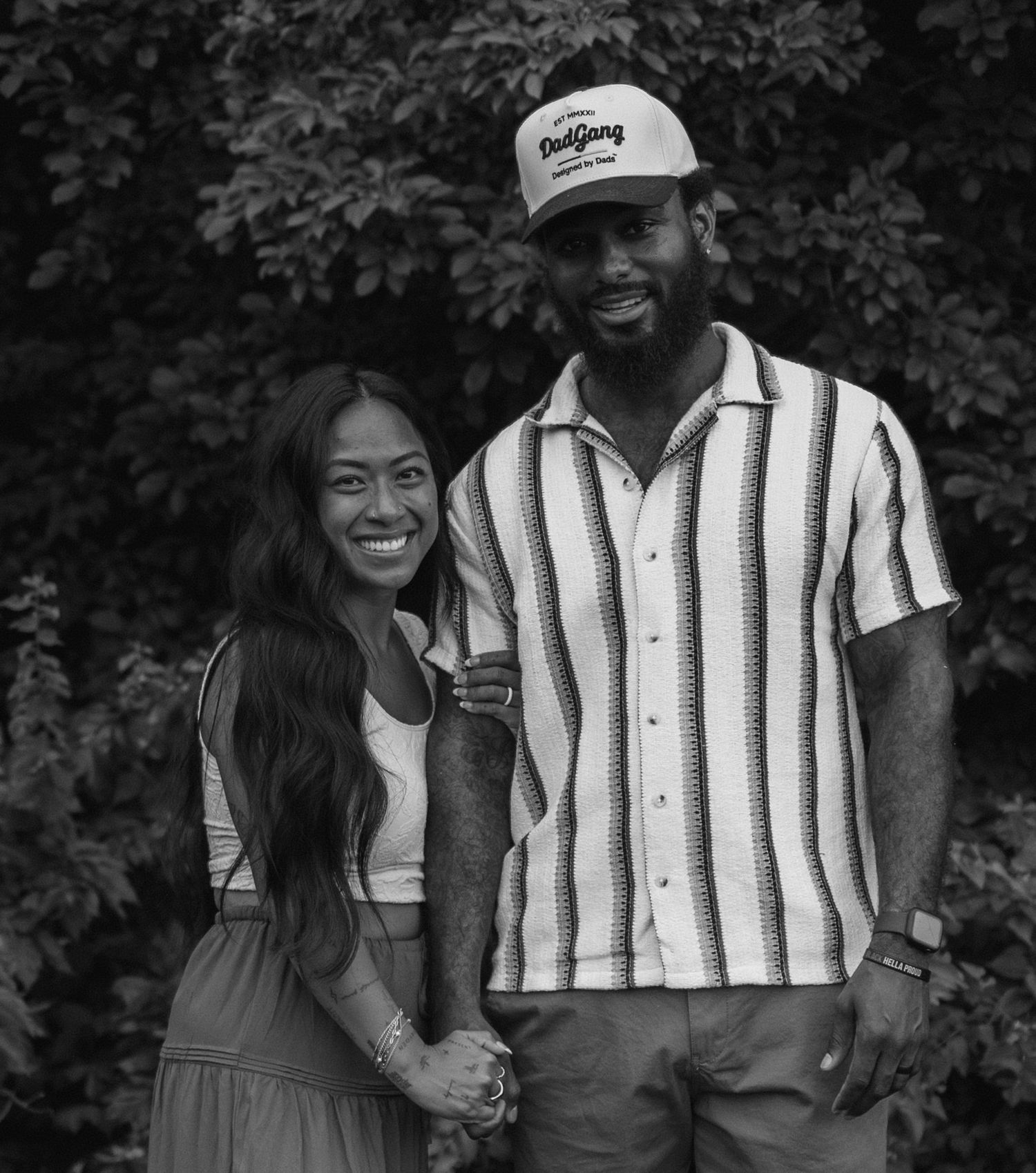 A series of four black and white photos showing a couple laughing and embracing outdoors.