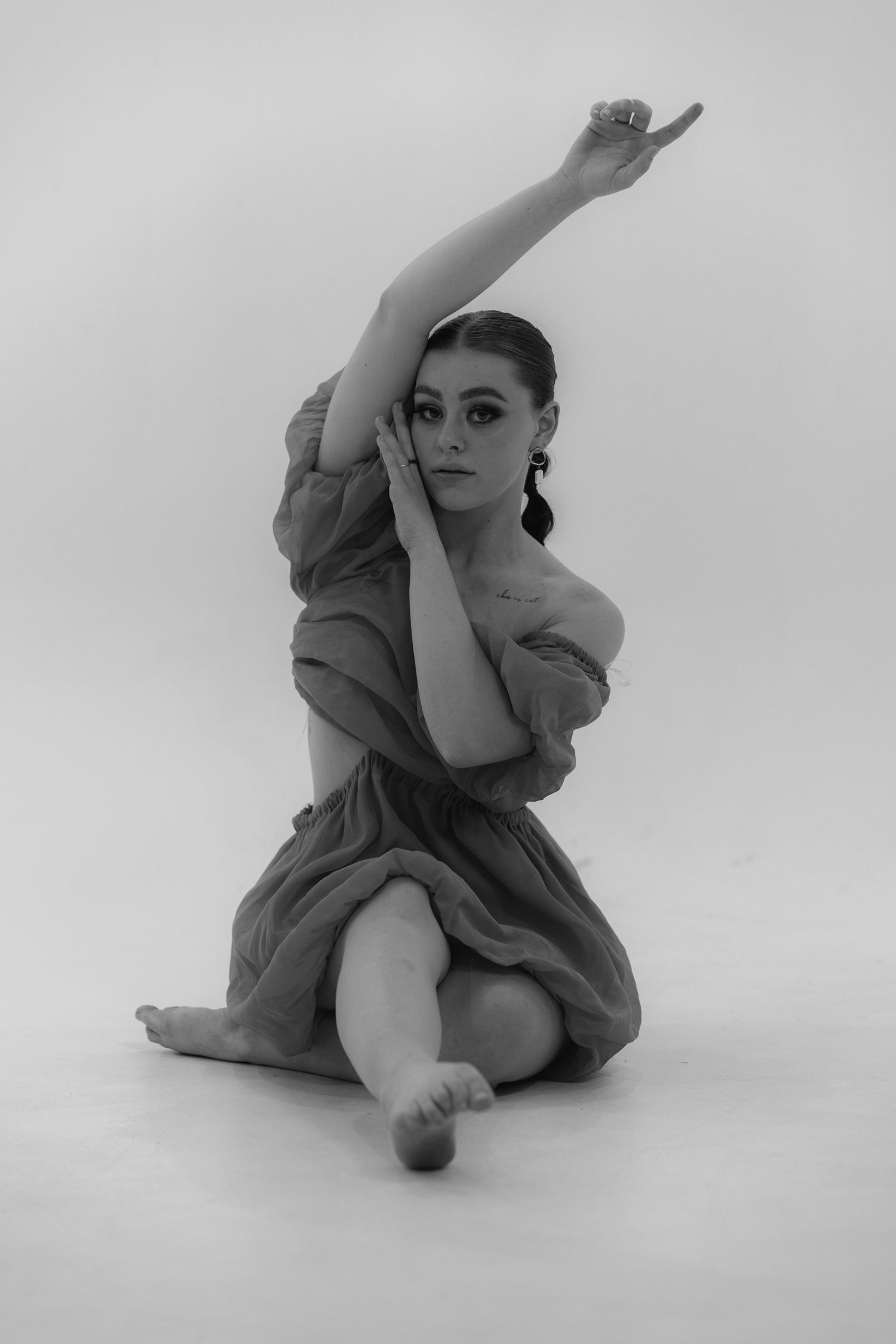Artistic black and white photo sequence showing graceful dance movements and flowing fabric against white background.
