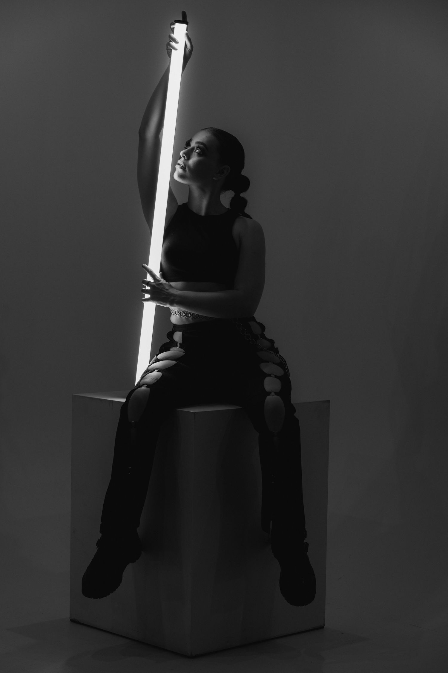 Dark moody artistic black and white photo series showing a toy bear sitting on a cube illuminated by dramatic lighting.