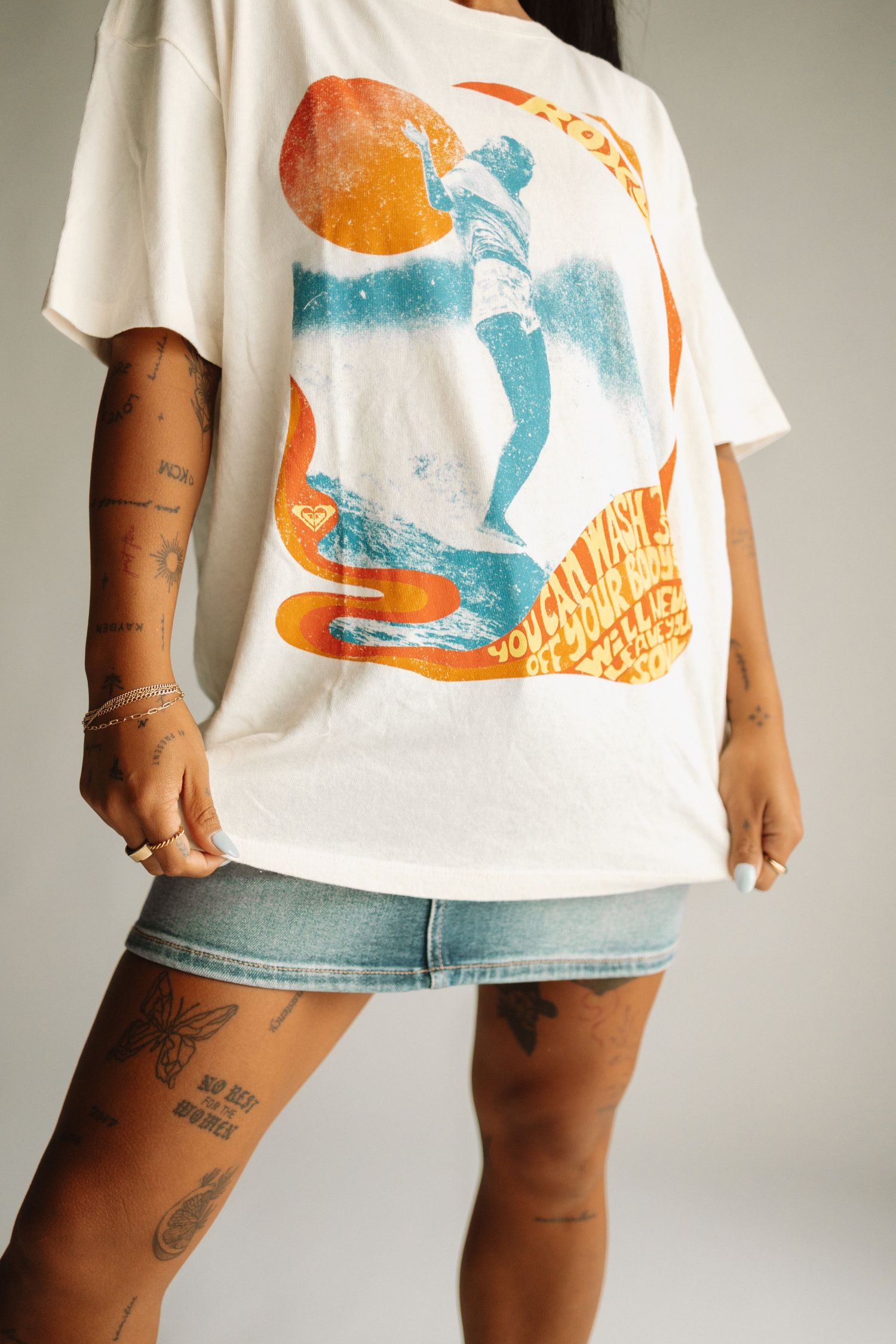 White graphic t-shirt with orange and blue design paired with denim shorts shown from different angles.
