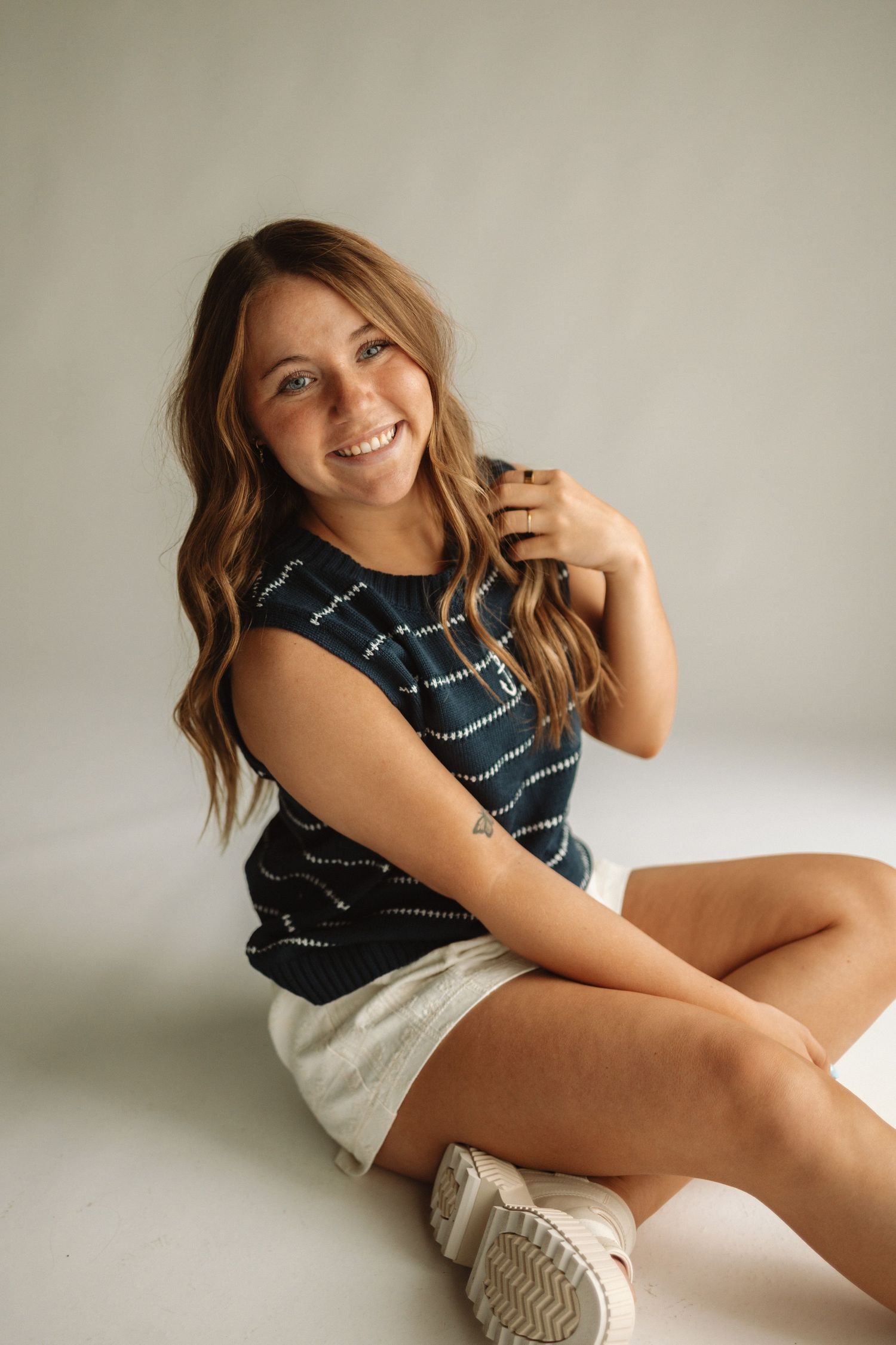 Lifestyle photo series showing poses against white backdrop wearing striped top and white shorts.