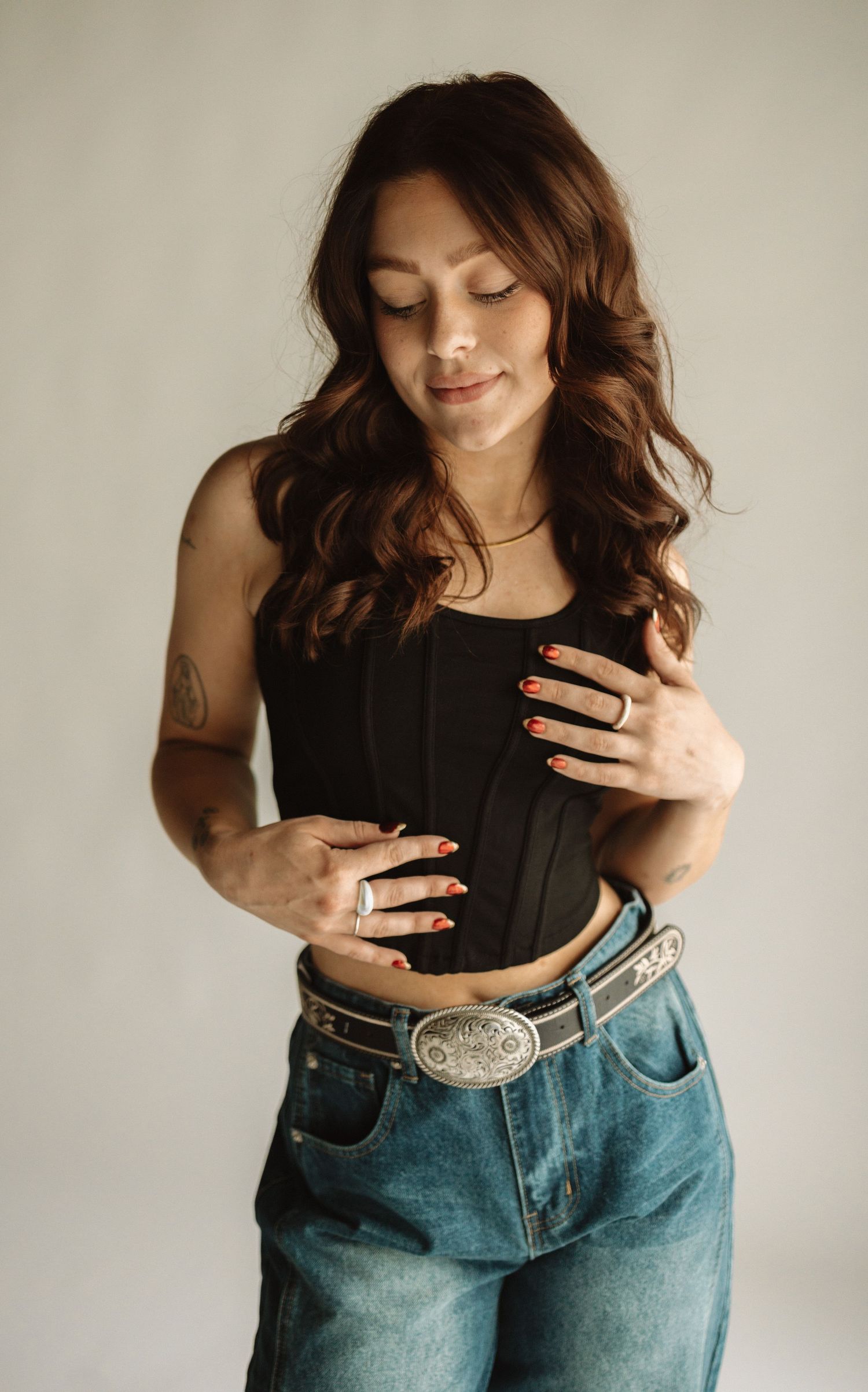Three artistic self portrait photos showing a person in black top and blue jeans against a light background.