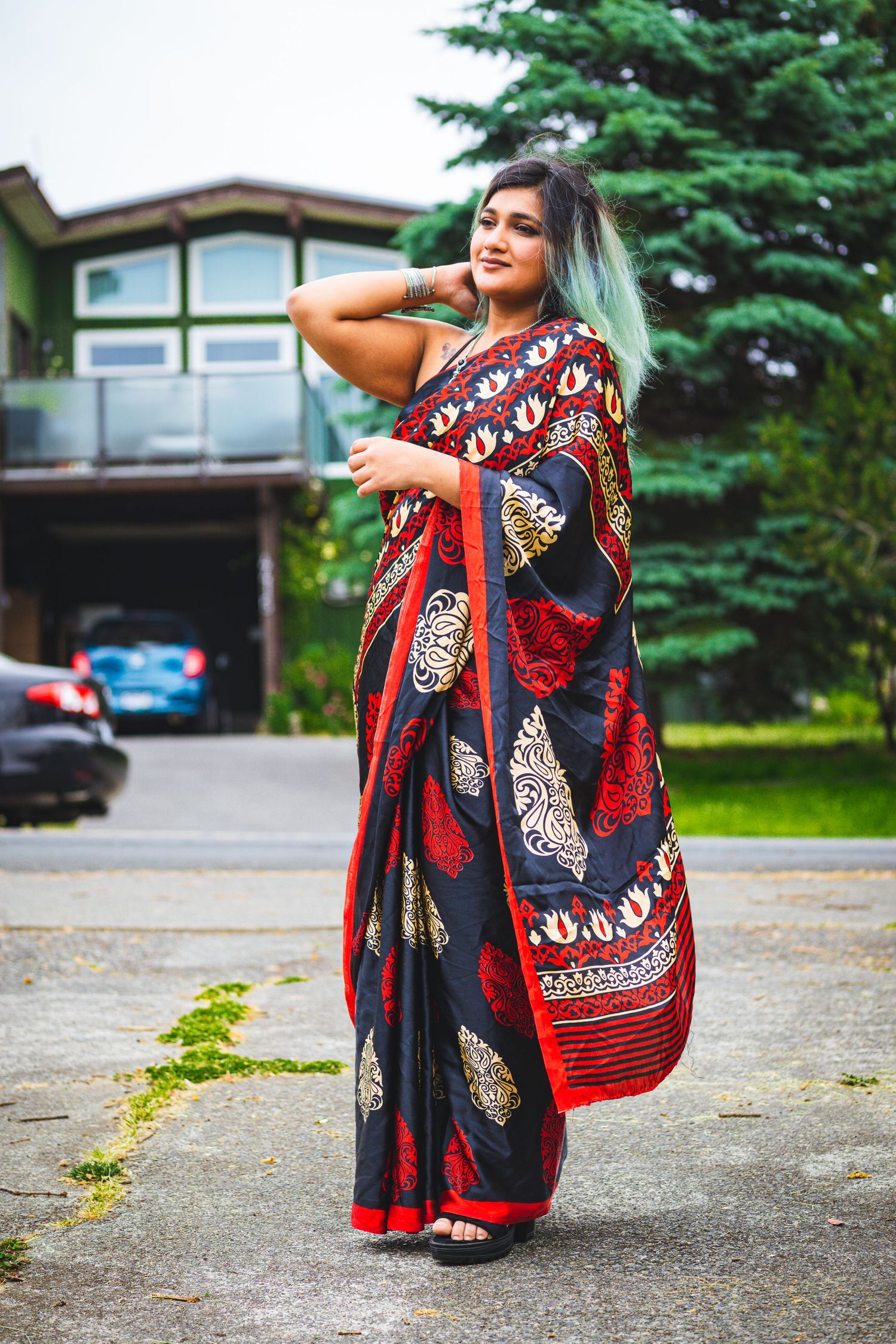 Modern twist on Indian tradition — woman twirling in red sari in open space