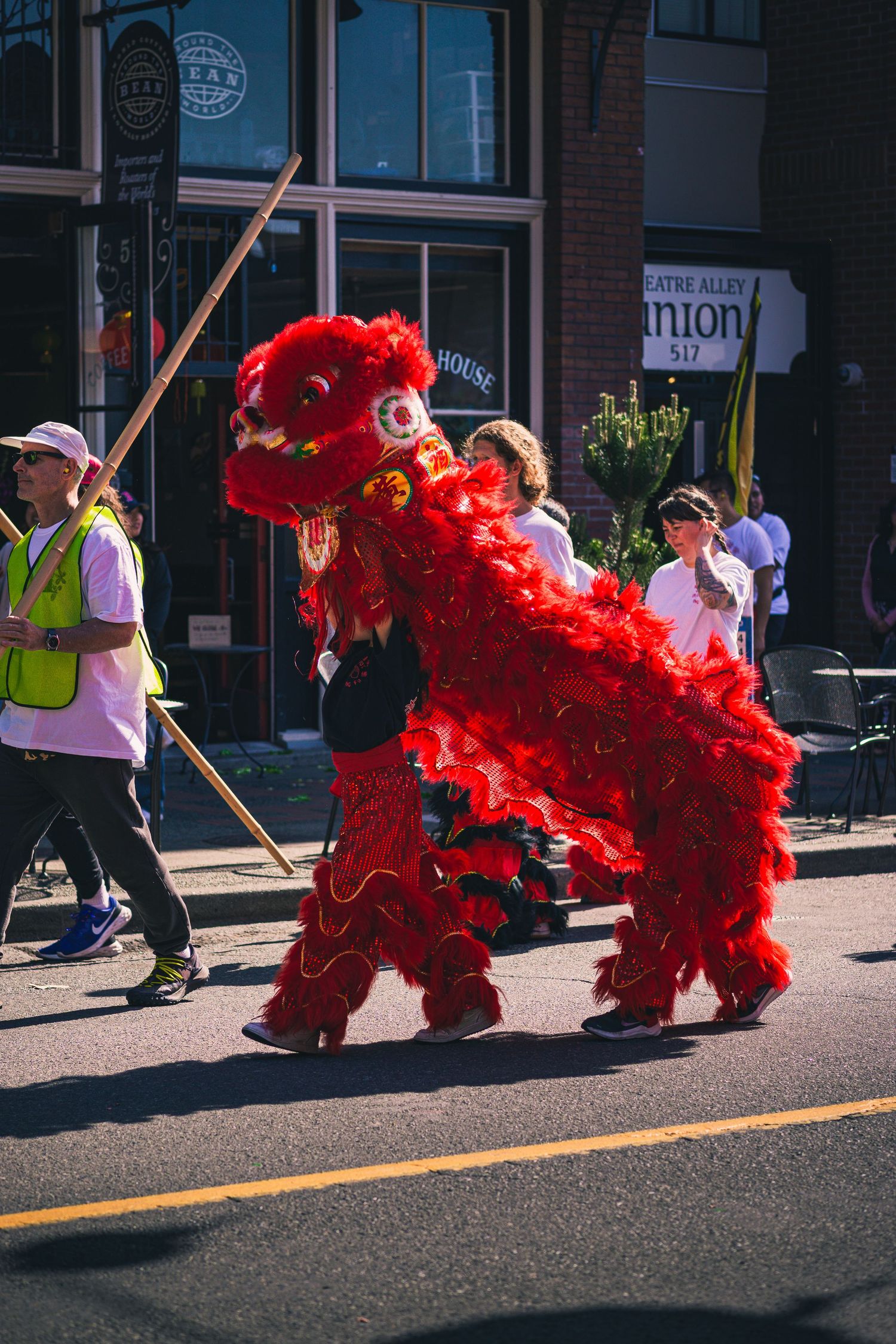 Bright red lion costume mid-dance during Chinatown cultural celebration