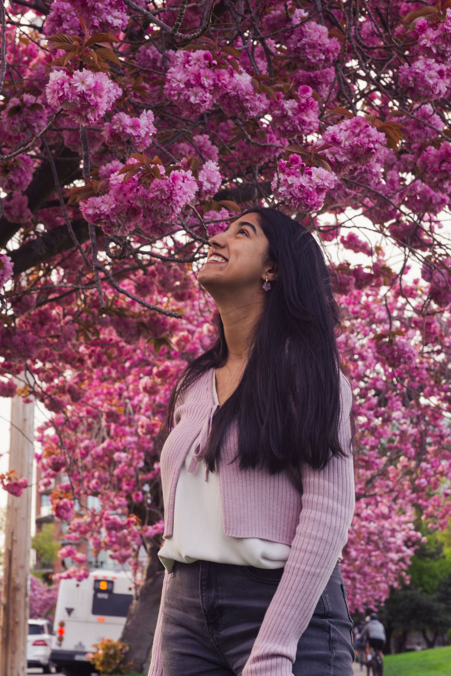 Happy candid of woman surrounded by cherry blossoms in full bloom in Victoria, Canada