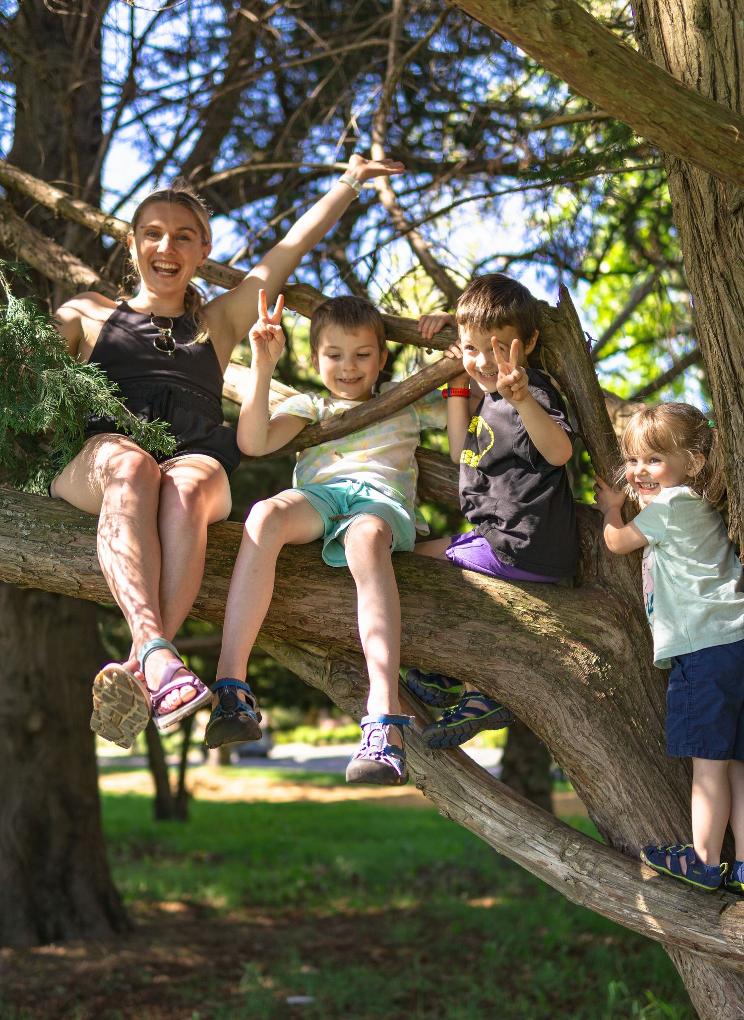 Group of kids playing on the short tree trunk and posing for a picture in the park