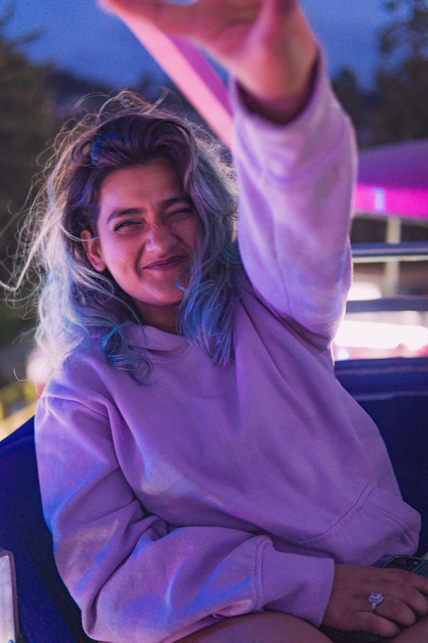 Joyful nighttime shot of woman at fair, surrounded by energy and color in Victoria, Canada